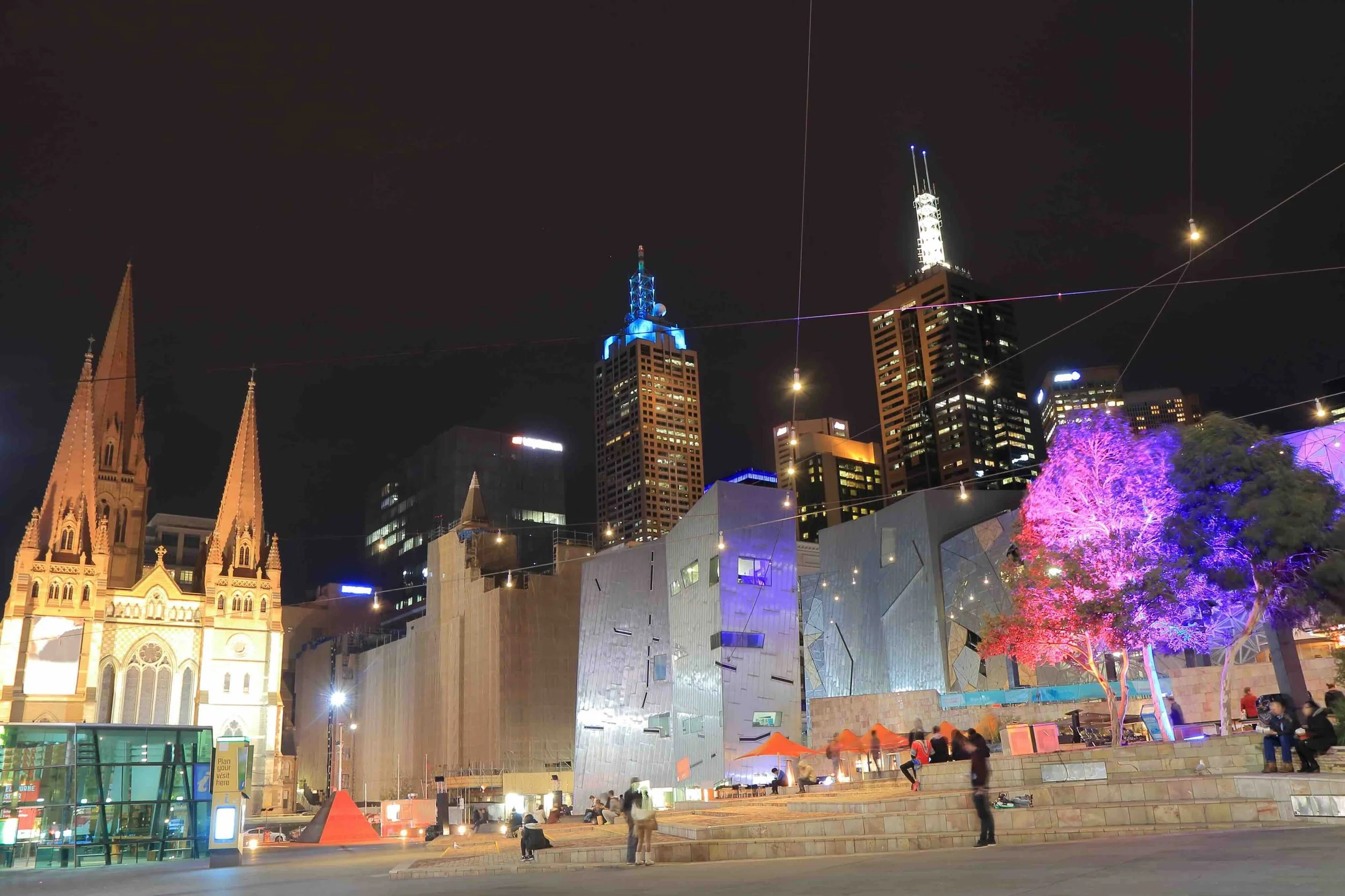 Federation Square illuminated at night alongside St Paul's Cathedral, Melbourne — a hub of culture, design and innovation explored on Libertas Travel's Melbourne Innovation high school excursion.
