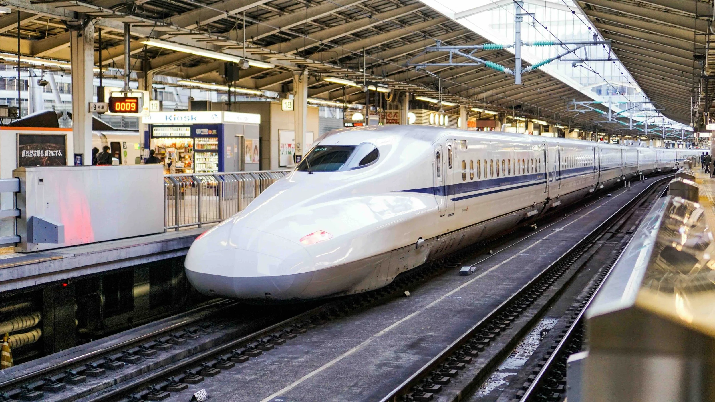 1 | Day 1, Tokyo | Shinkansen bullet train at a Tokyo station platform — captures Japan's high-speed rail network, setting up the "future of transportation" theme explored later at the Maglev Exhibition Centre.