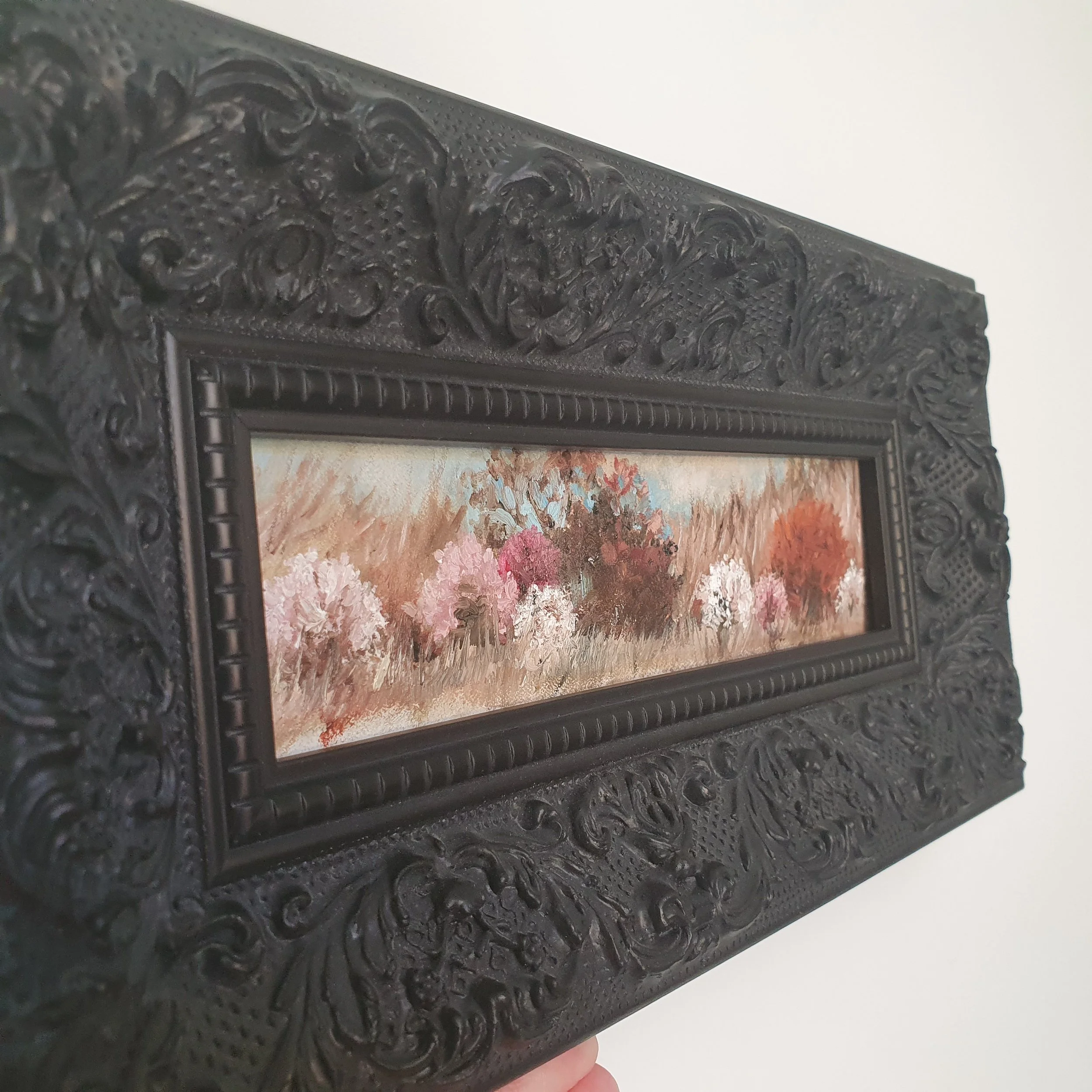 Miniature oil painting in black ornate frame. Soft abstract landscape in natural earth tones of light brown with cherry blossom.