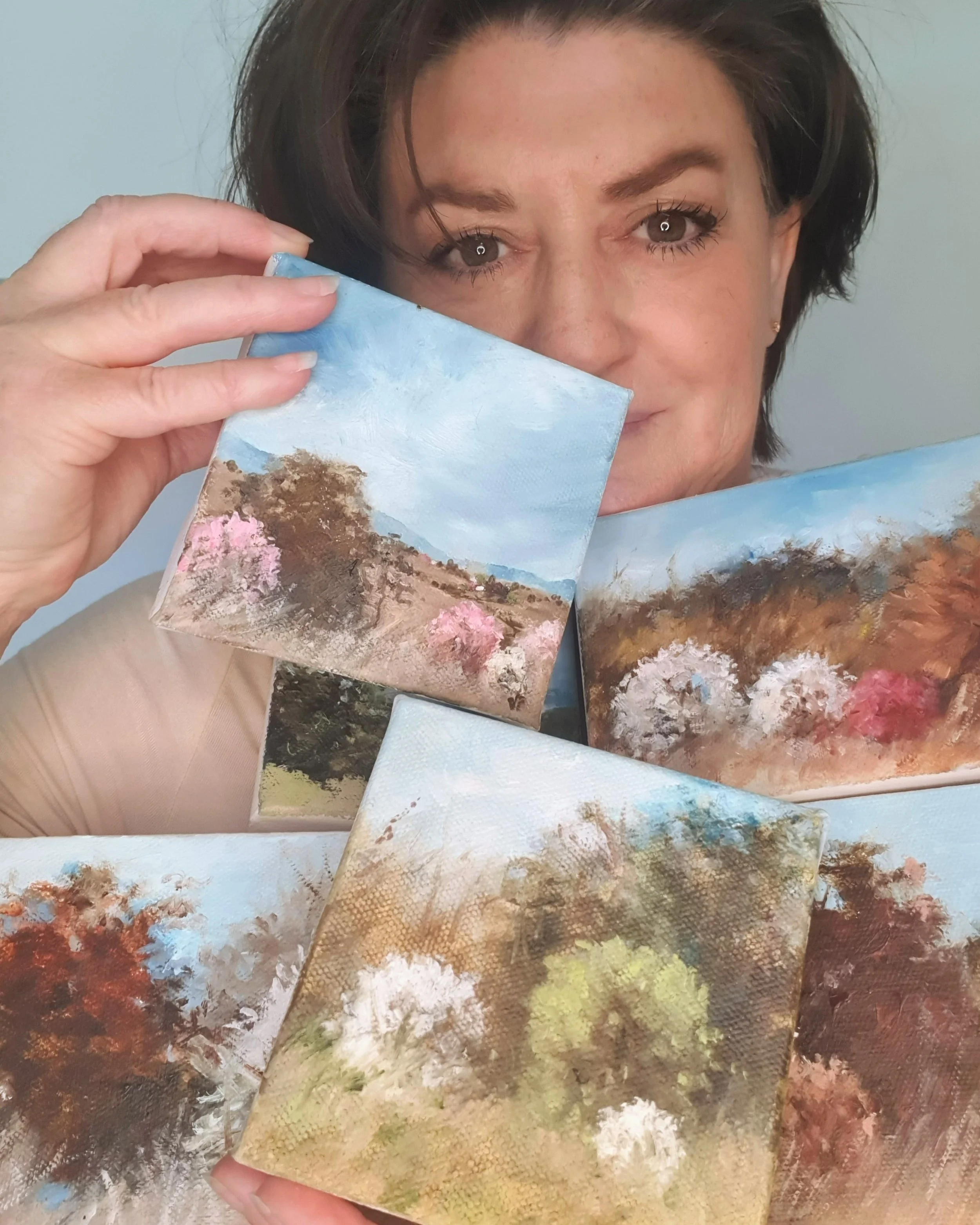 Canberra artist Victoria Pynt holding collection of miniature oil paintings