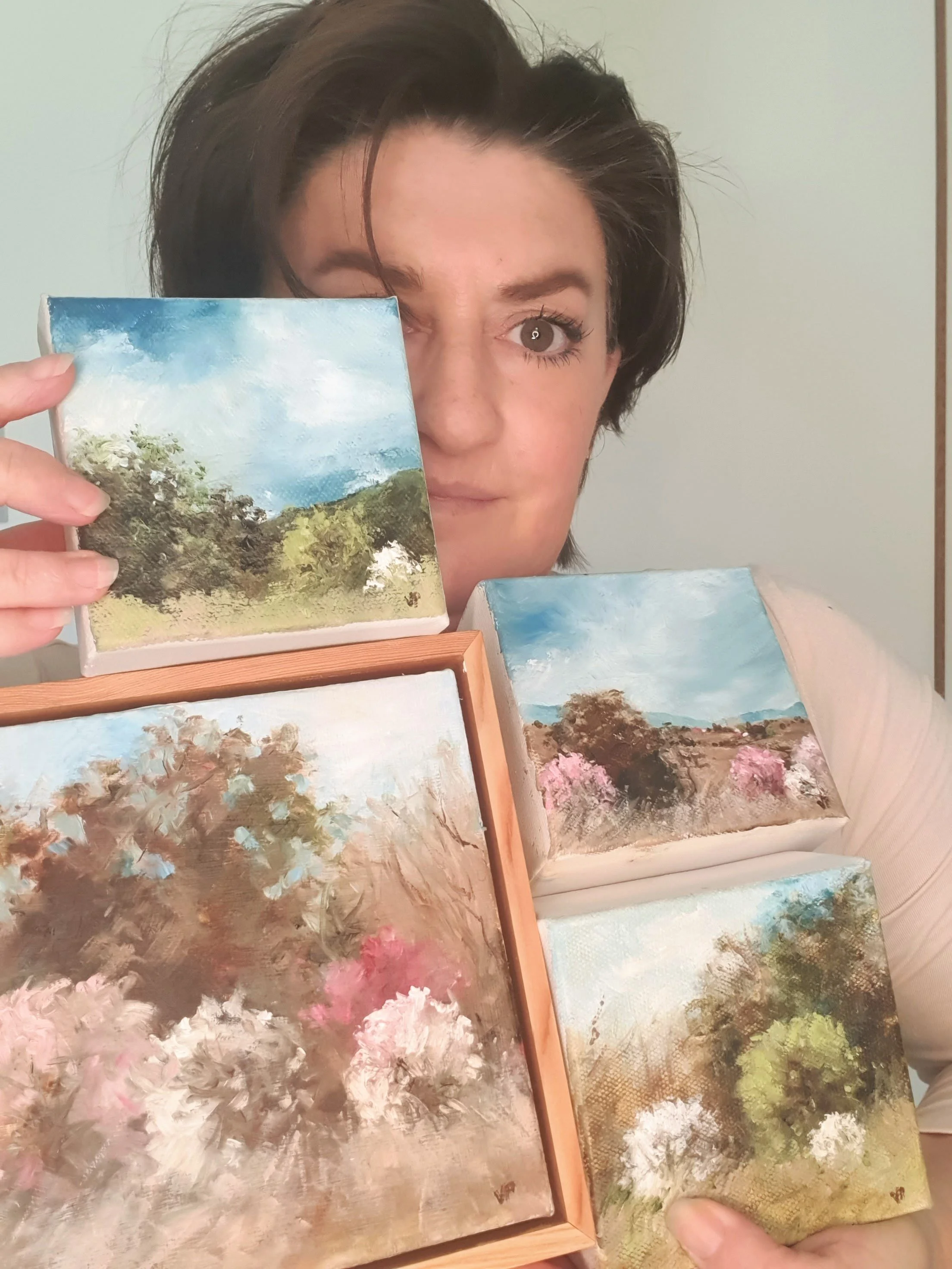 Australian artist Victoria Pynt holding collection of miniature oil paintings
