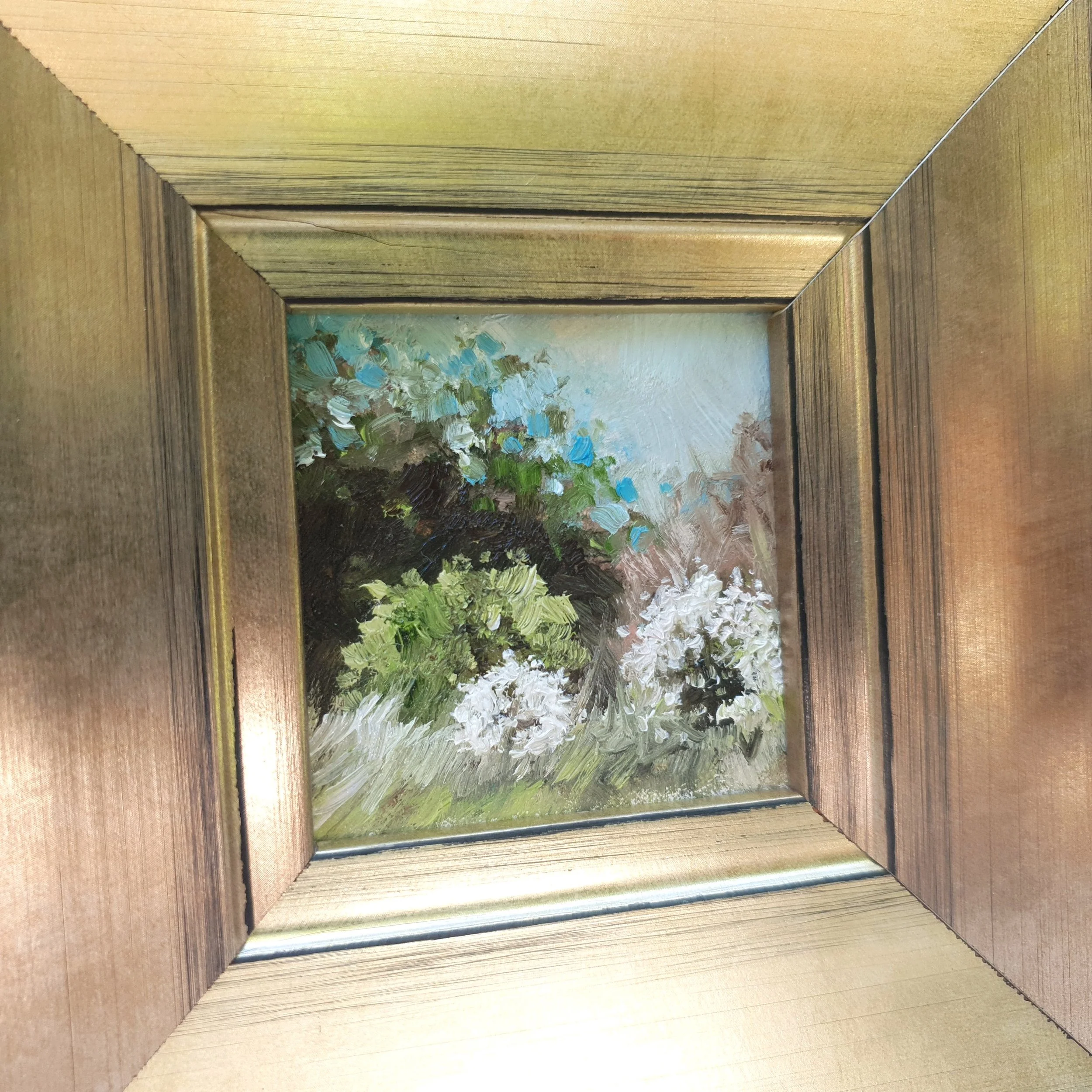 Framed miniature oil painting of rustic country scene with white blossom tree.