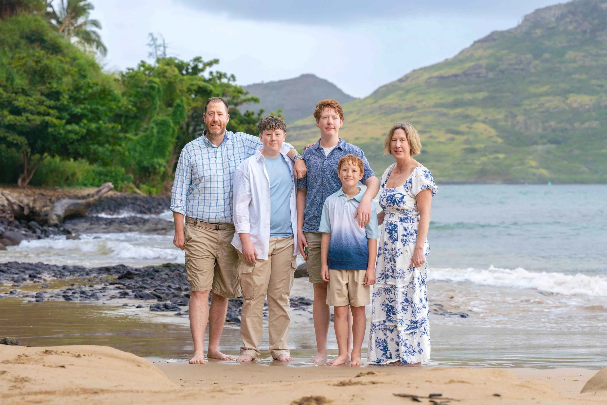 Family of five with three sons posing on a Kauai beach.