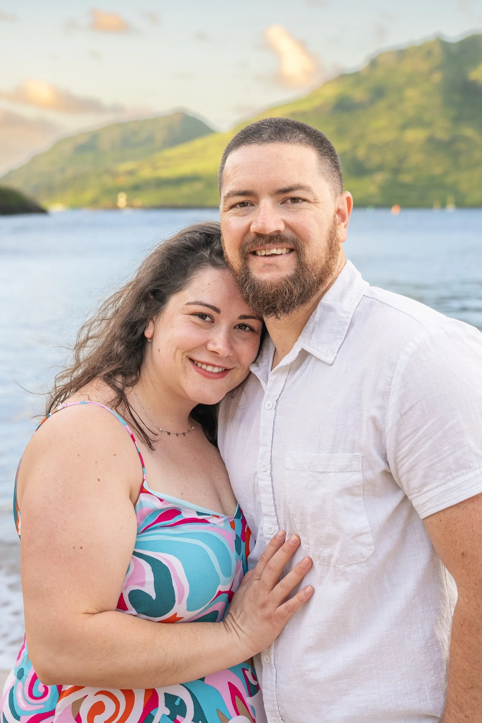 Happy couple with the woman leaning on the man's shoulder on a Kauai beach.