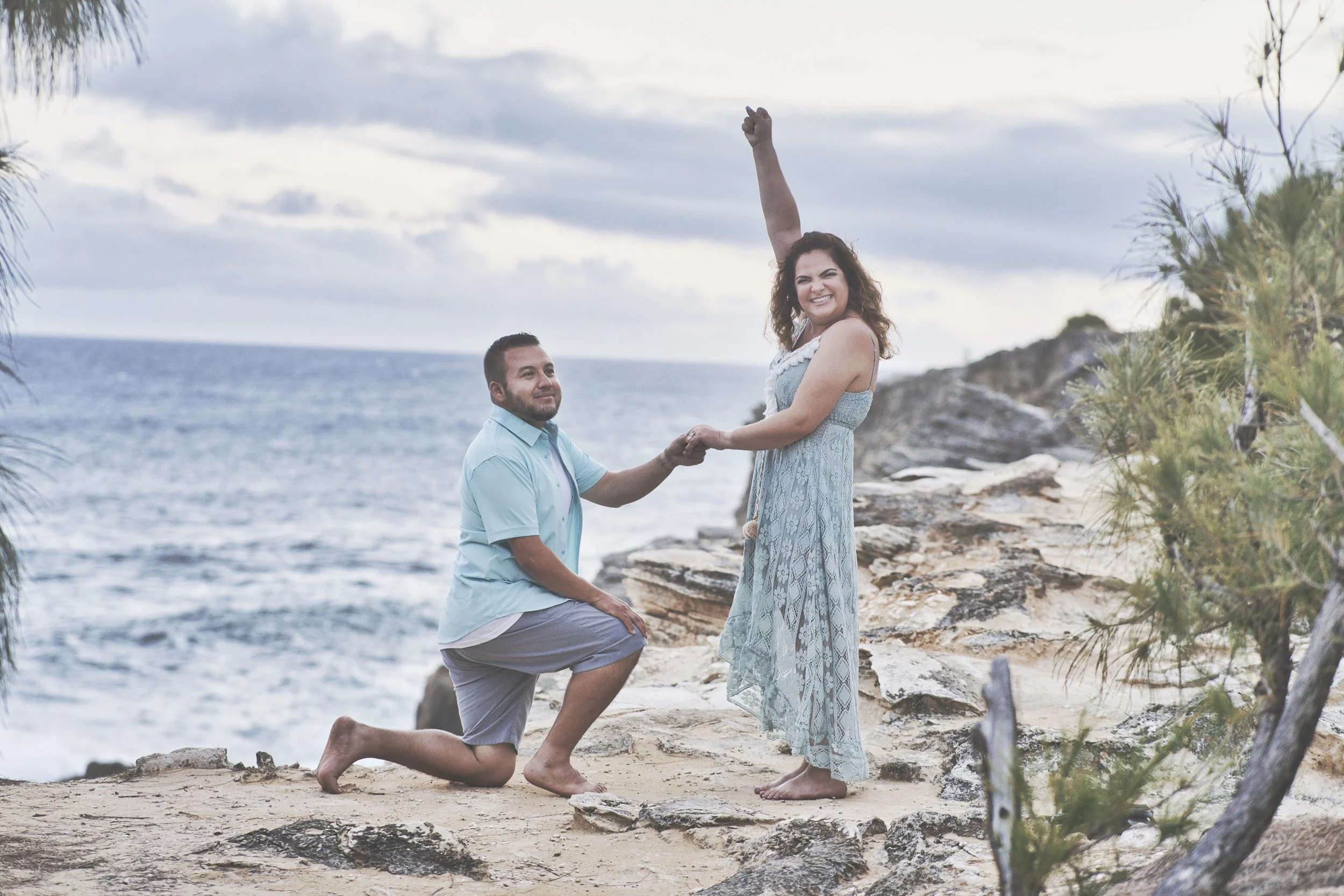 Man proposing on one knee on a cliff at Shipwreck Beach, Kauai.