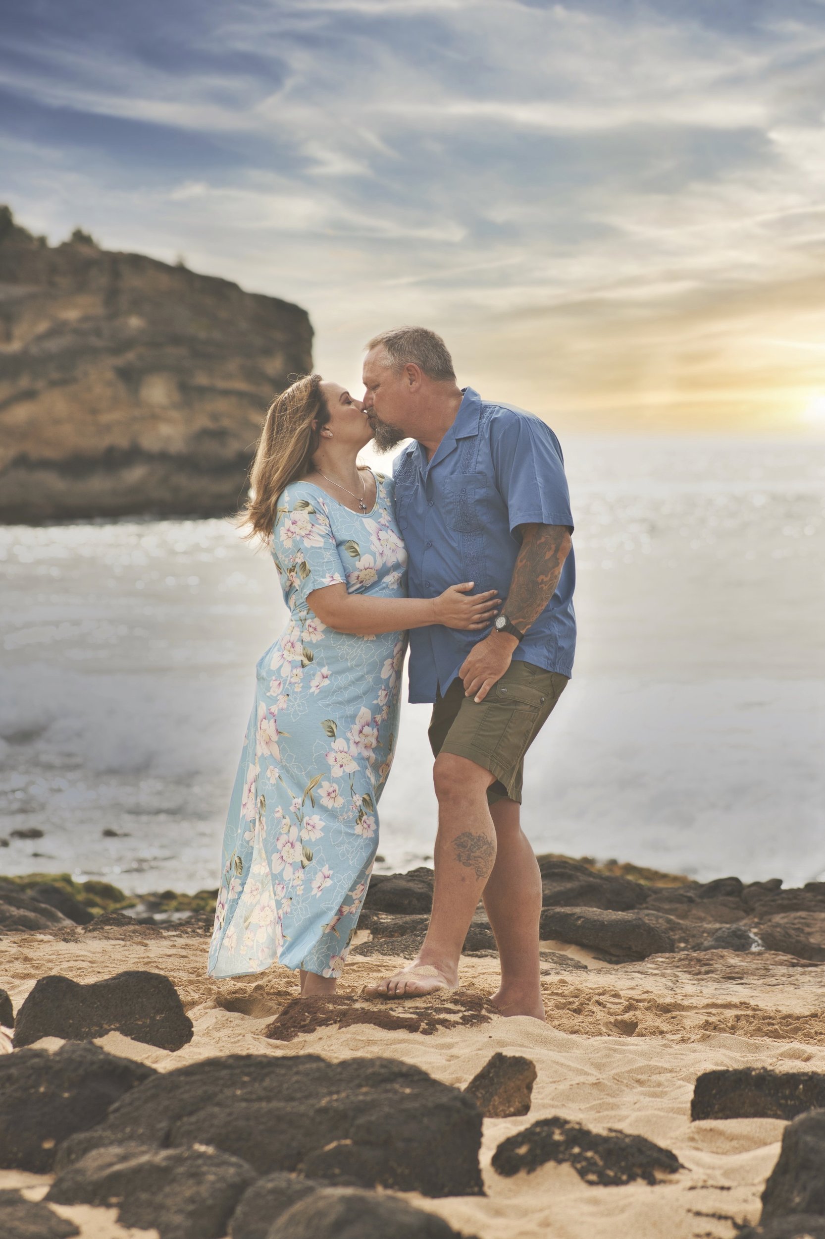 Couple kissing on the rocky beach at Shipwreck Beach, Kauai.