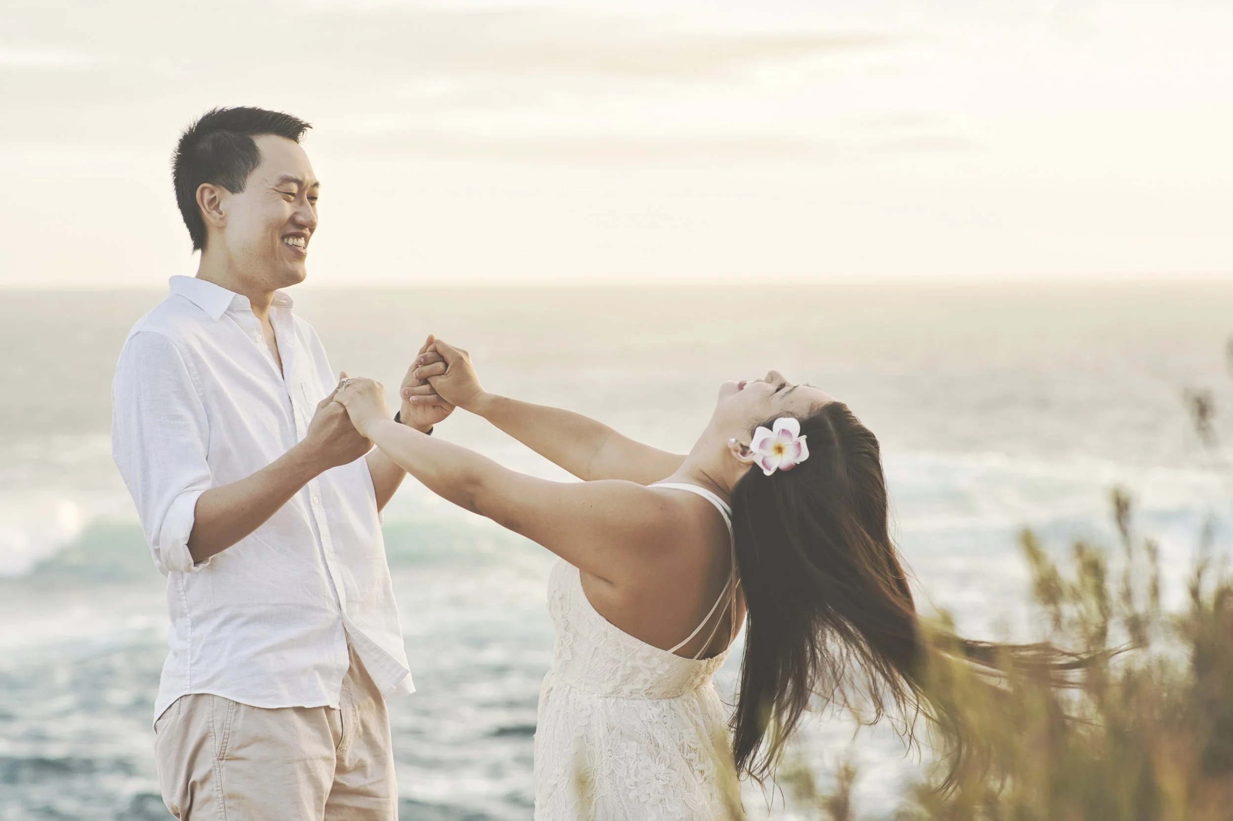 Couple dancing on a cliff top at Shipwreck Beach, Kauai.