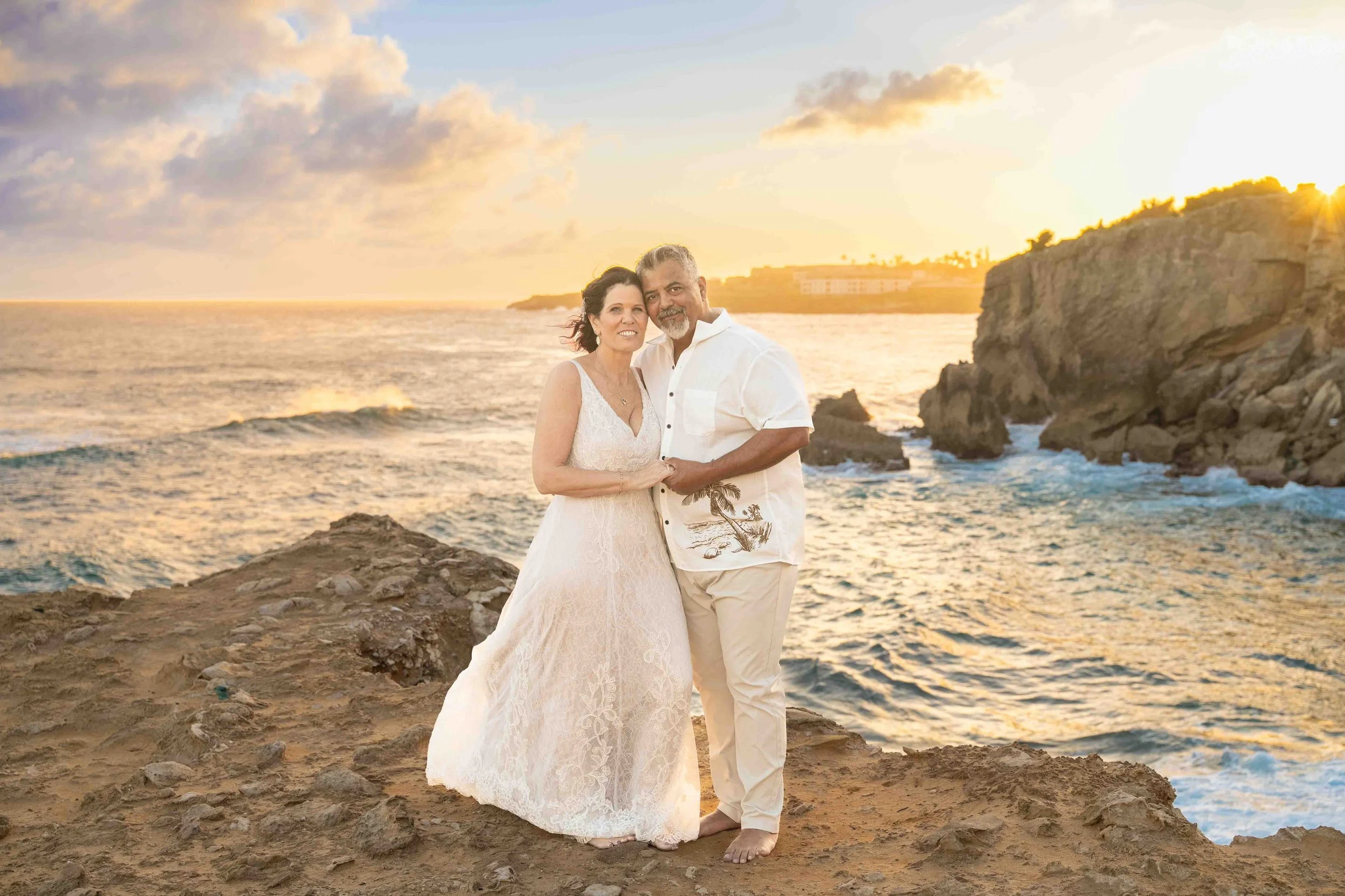 Older couple posing on a cliff top at sunset at Shipwreck Beach, Kauai.