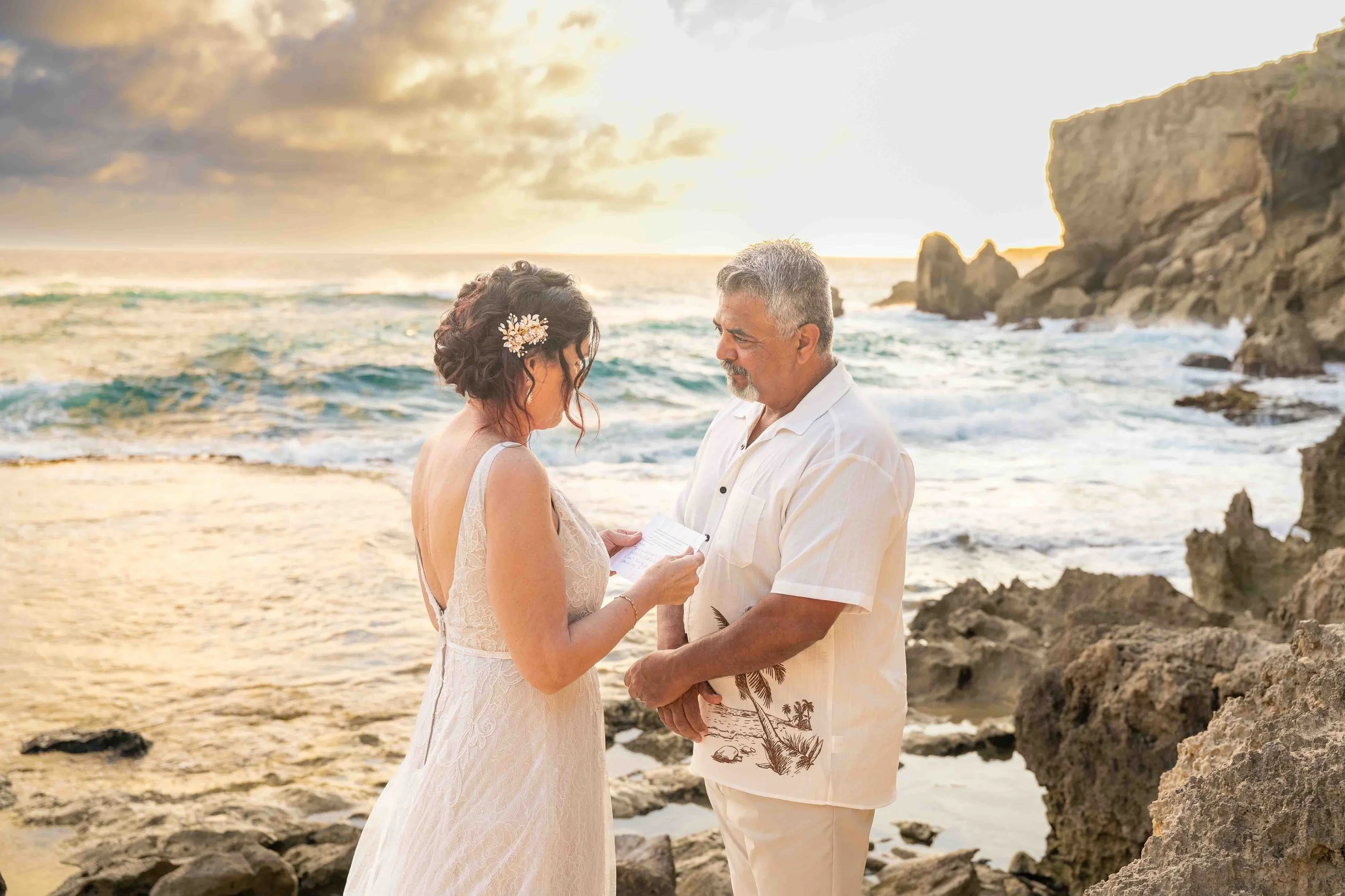 Mature couple holding hands on the beach at Shipwreck Beach, Kauai.