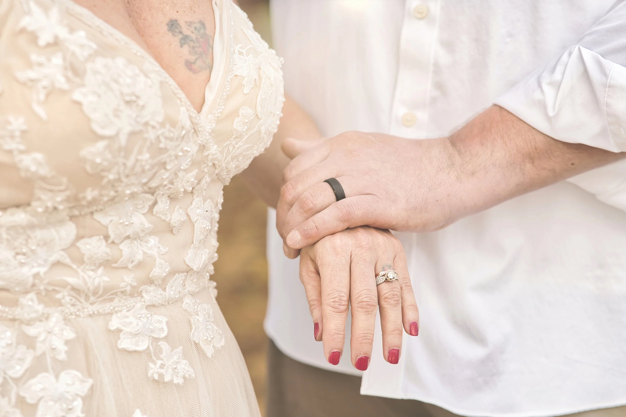 Close-up of a newlywed couple's joined hands showing their wedding bands in Kauai.