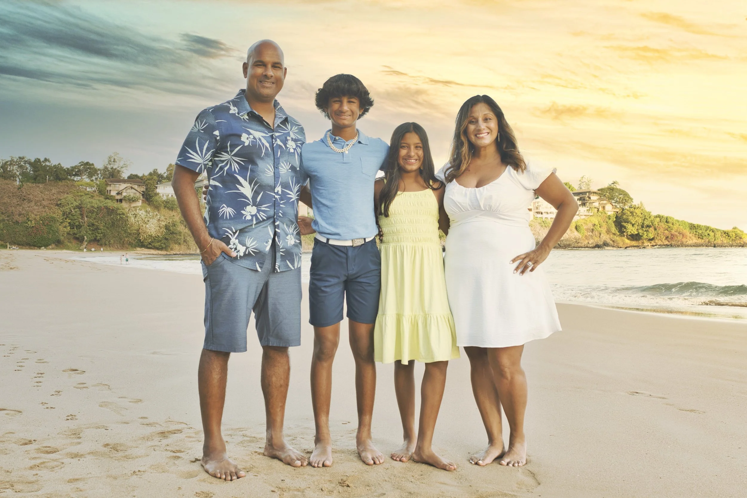 Parents and two teenagers pose on the sand at sunset during a Kauai beach portrait session.
