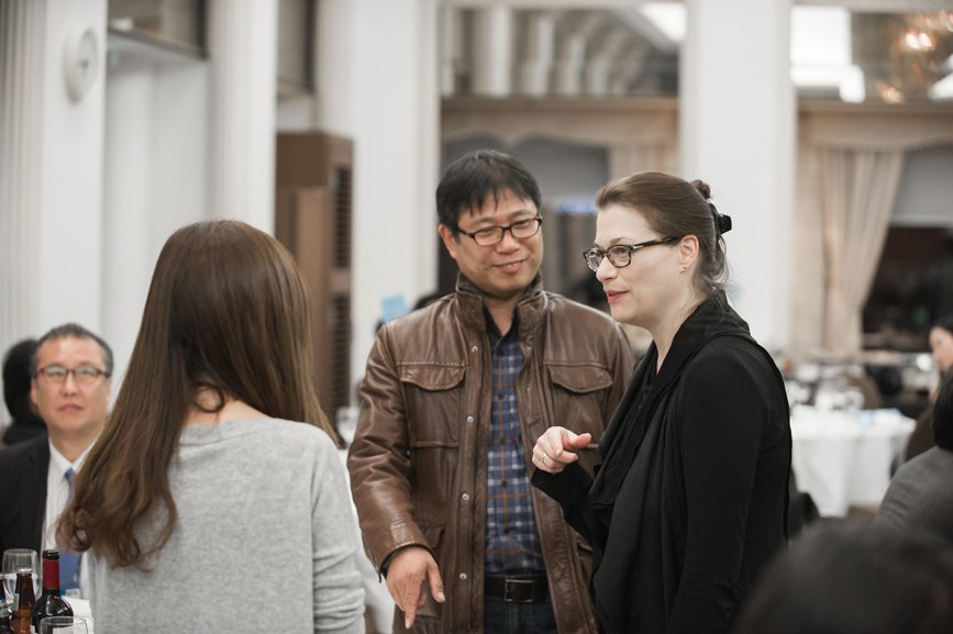 At the alumni gathering, Angie Wojak from the Career Development team is engaged in a conversation with one man and one woman.