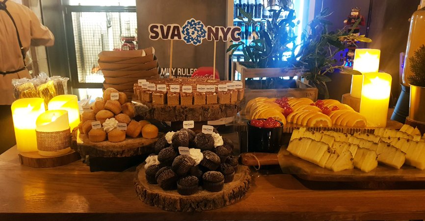 Here is a close-up of the food prepared for the event. In the background, there is a cake with a pin attached to it, featuring the lettering "SVA NYC."