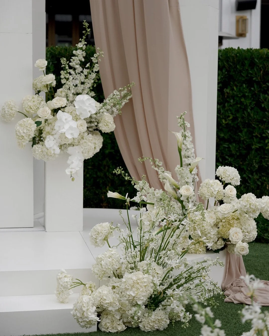 All-white ceremony florals and aisle arrangements layered around a modern ceremony structure for a romantic wedding moment. 

Bride and Groom: @jamie_comstock and @elarson34
Planning and Design: @westgate.events
Lead Planner: @cslundahl
Assistants: @
