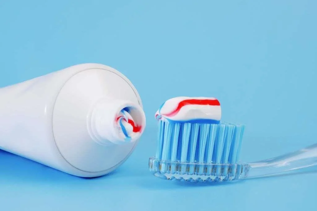 Toothbrush and toothpaste tube on a blue background