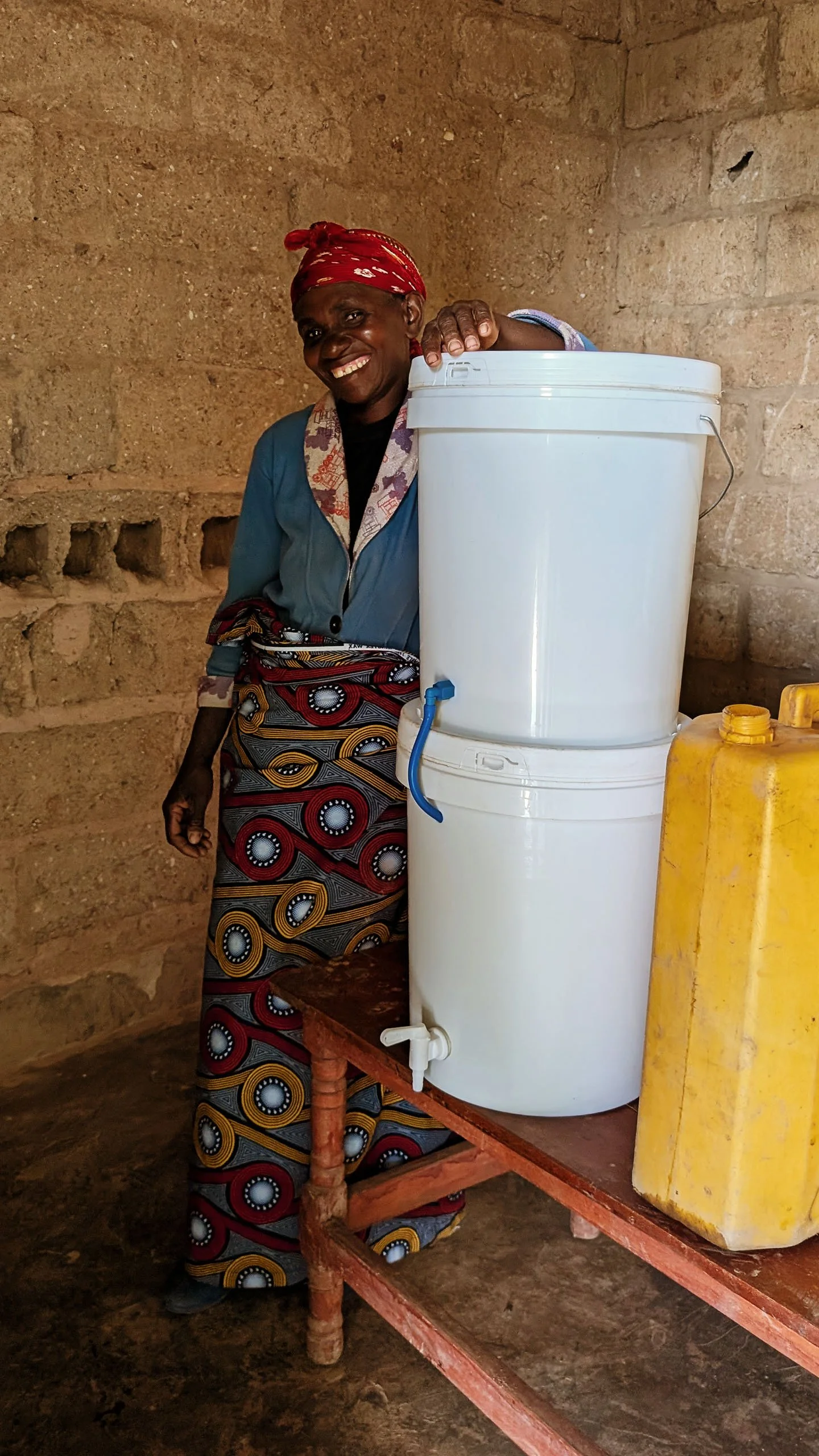 MightyWater_Rwanda2025_WomanWithFilterInHome_RobMiller.jpg