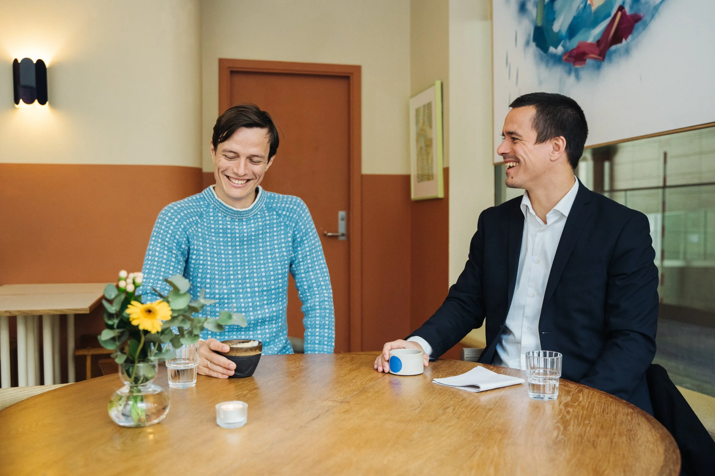 A person holding a yellow marker and drawing on a detailed construction or engineering blueprint laid out on a large white table.