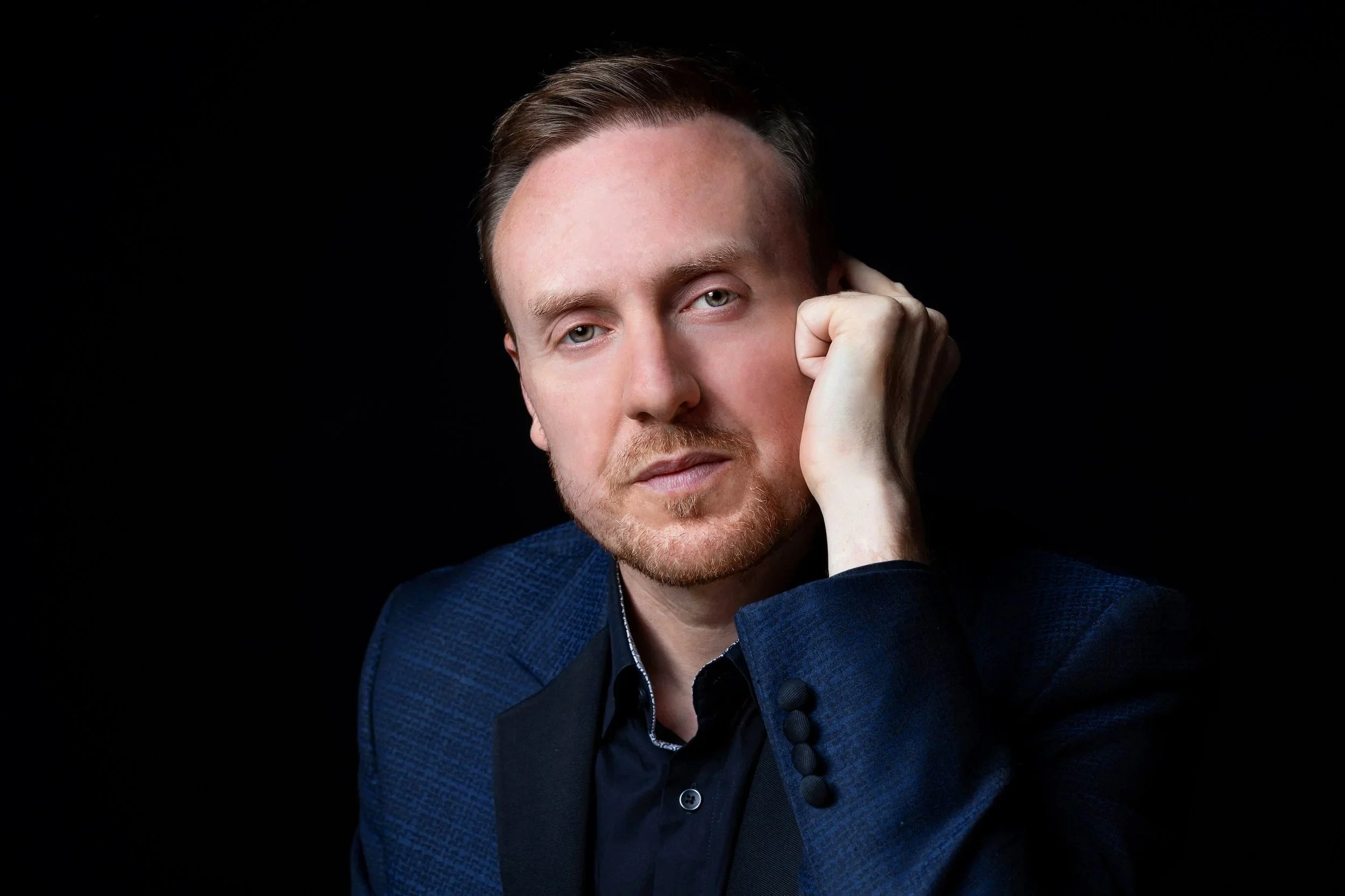 Studio portrait of Griogair Labhruidh wearing a blue blazer, photographed by Emily Butler, 2026.
