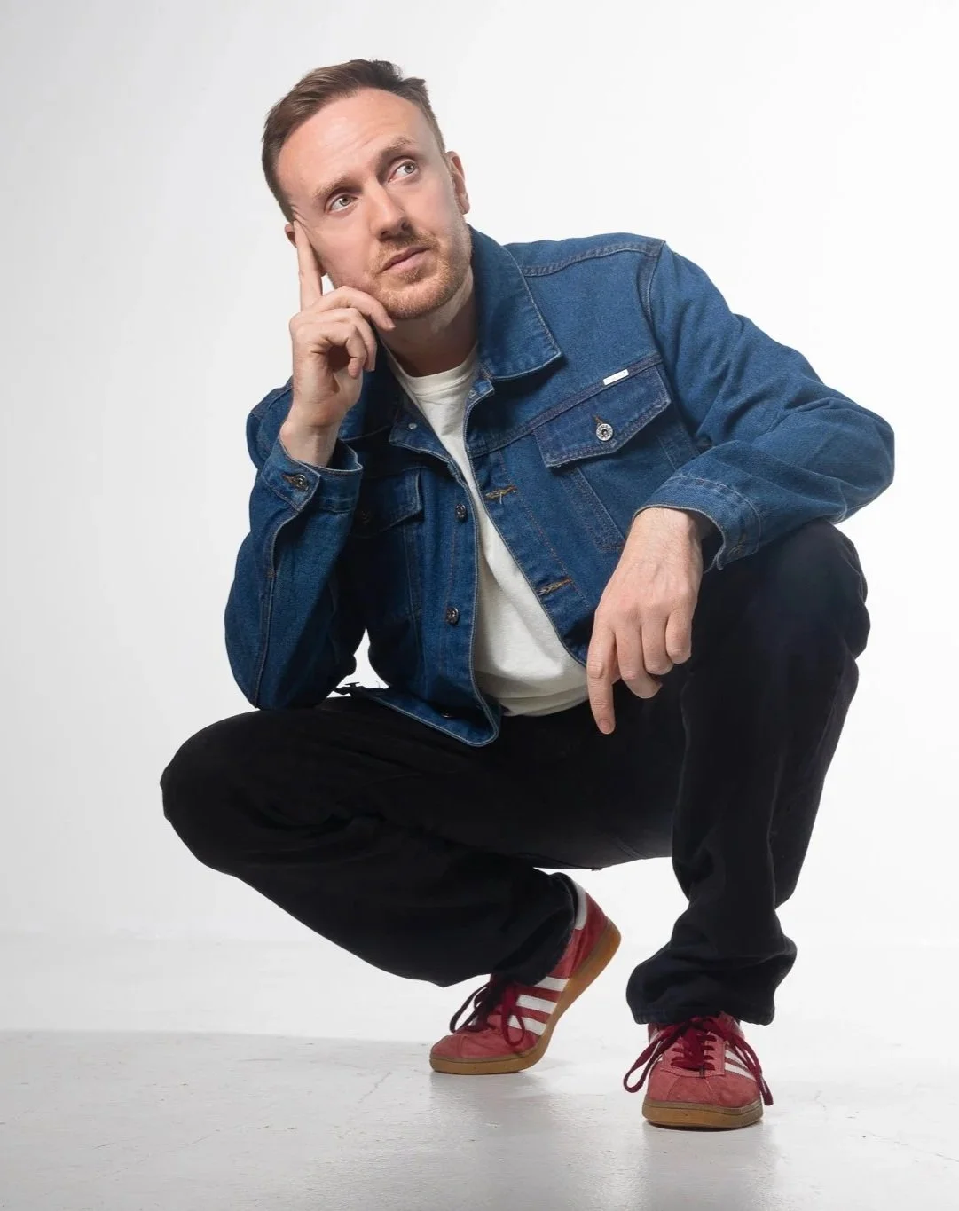 Portrait of Griogair wearing a blue denim jacket and red trainers, photographed by Emily Butler, 2026.