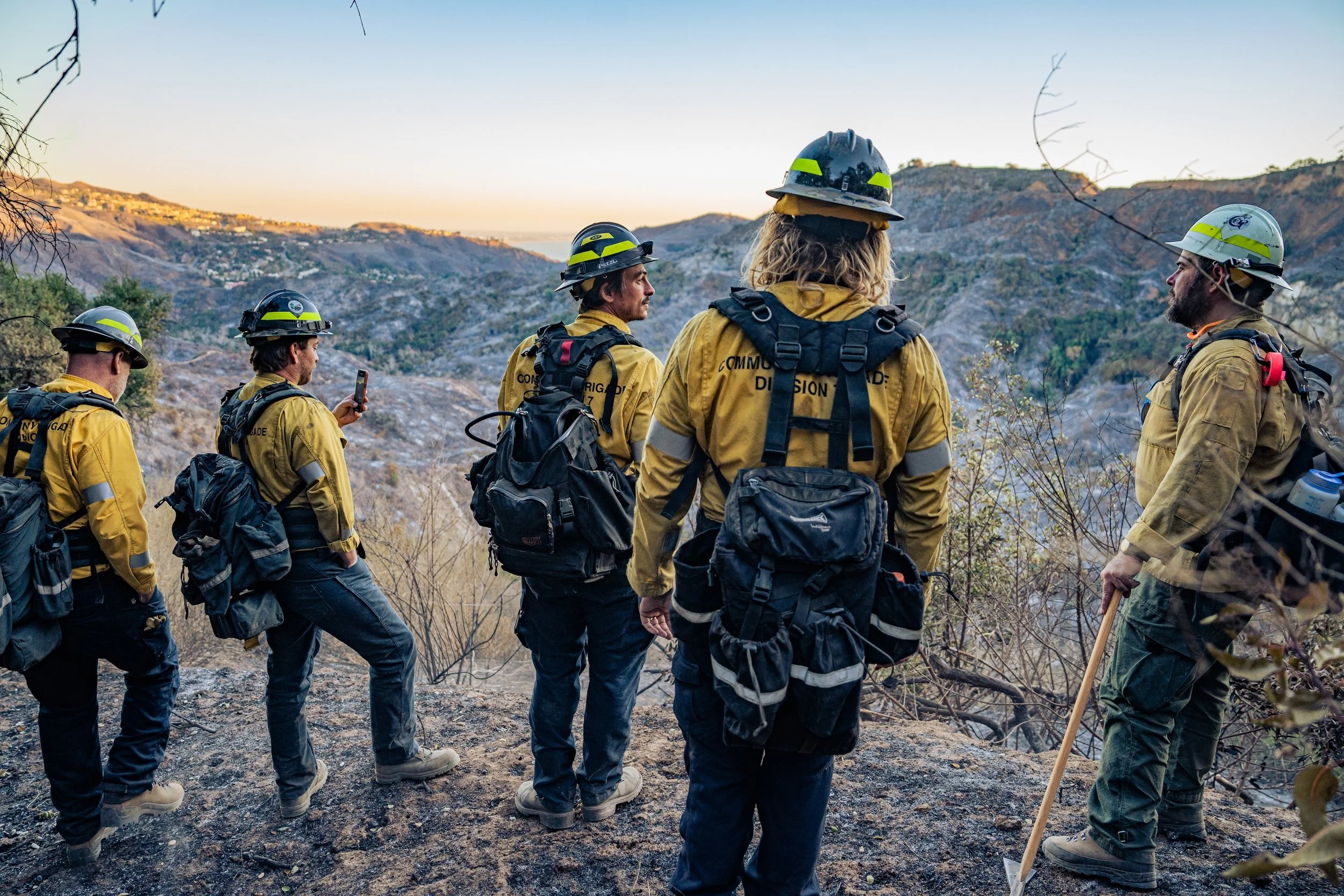 Community Brigade members survey some of the 23,000 acres scorched by the Palisades Fire in Santa Monica Mountains in the days after the Palisades Fire.  From left to right Brigade members: Charlie Wilkinson, co-founder Tyler Hauptman, co-founder Kee
