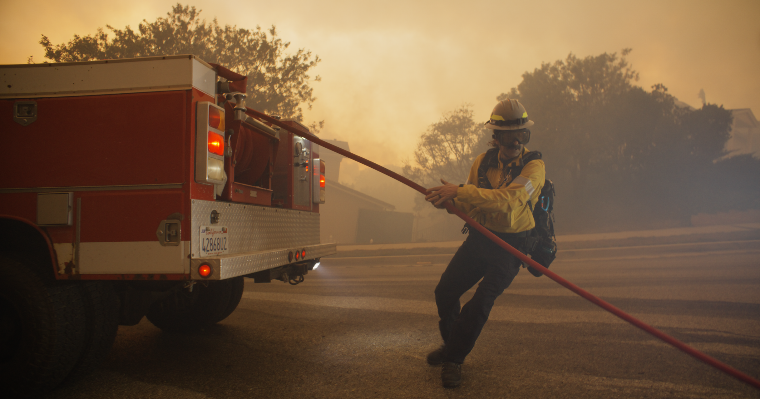 Community brigade member Aron Marderosian laying out hoses to get ready to put out hotspots. 

 Photo Credit: Connor Nelsen