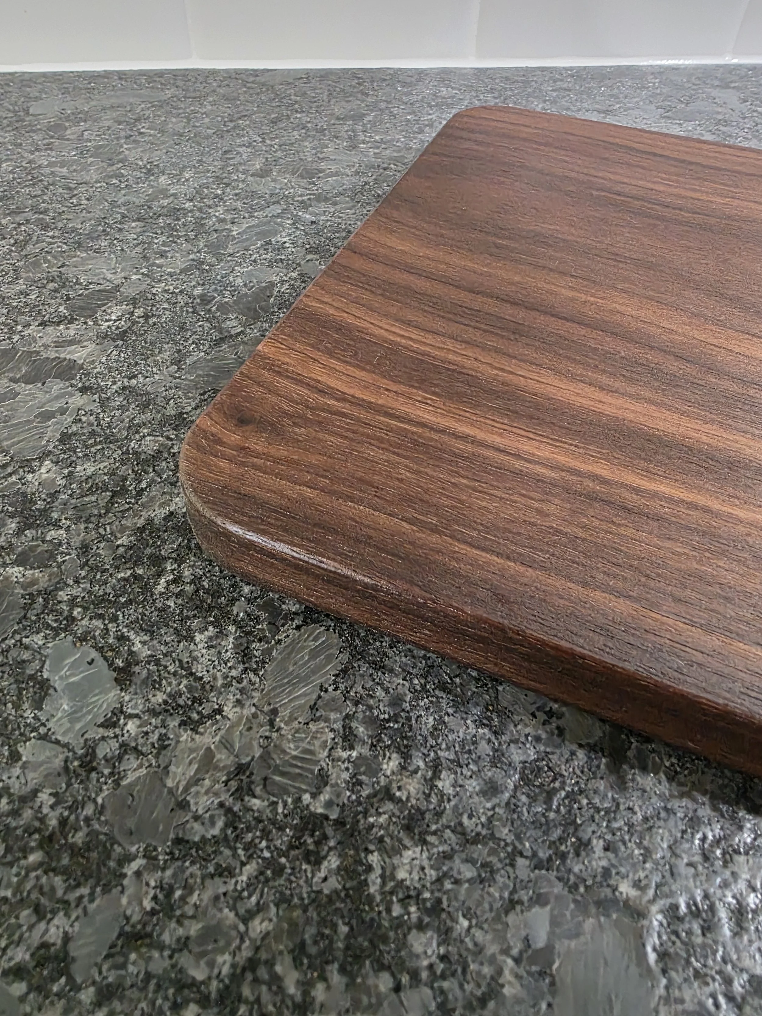 Solid american black walnut classic cutting board close up of corner.