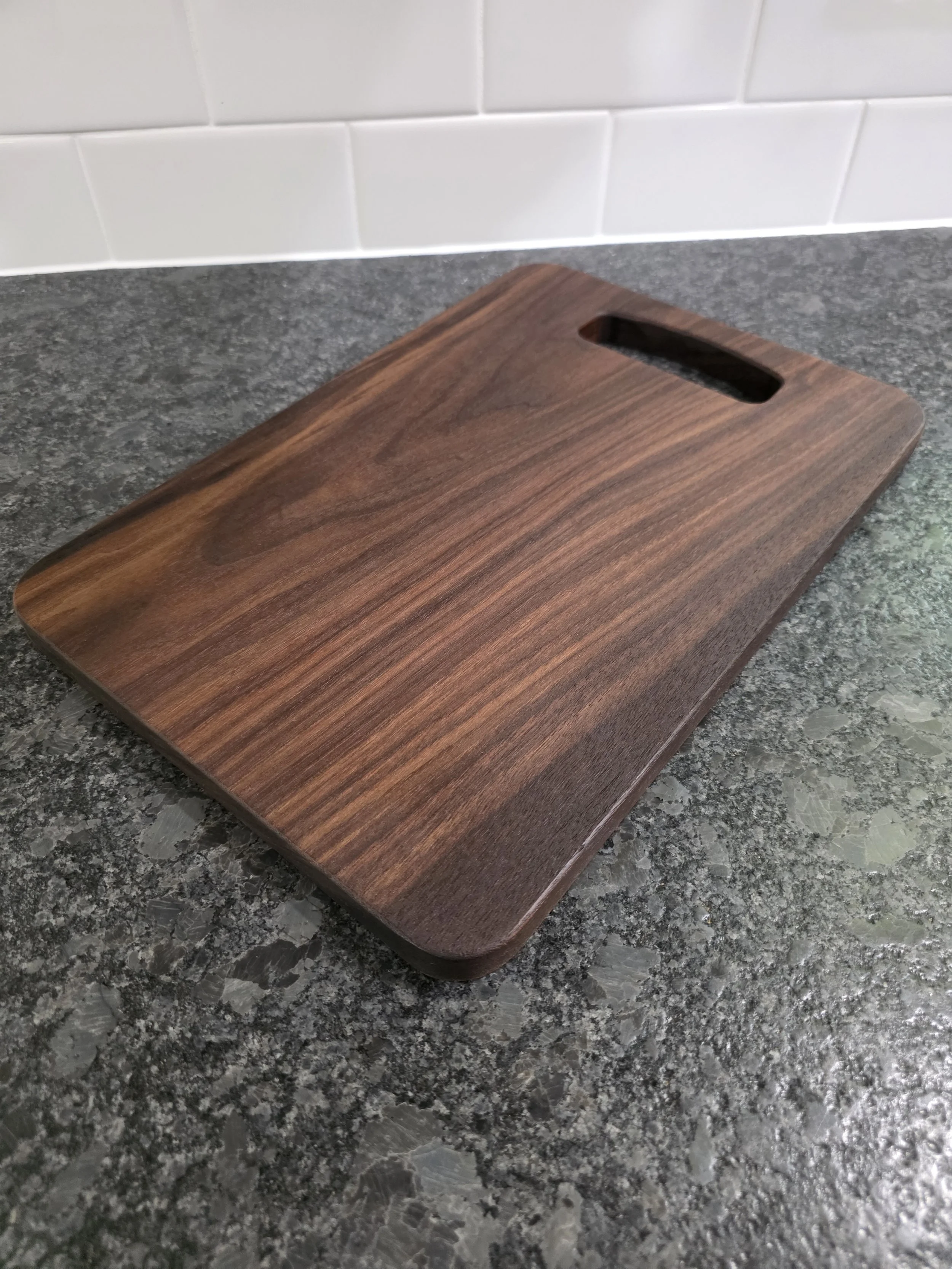 Solid american black walnut cutting board on counter.