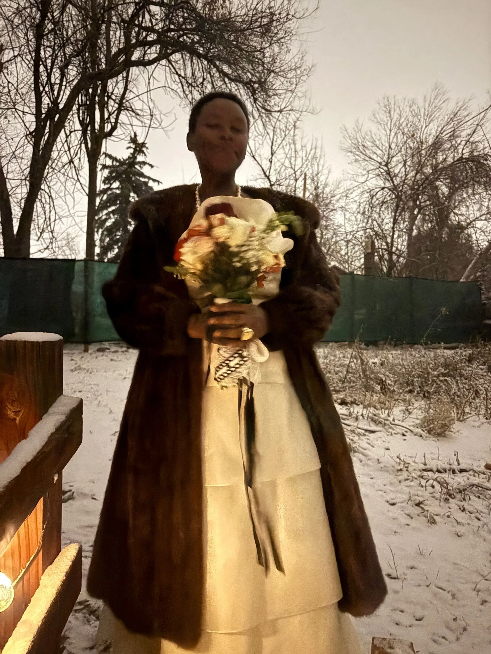 Person holding a seasonal wedding bouquet outdoors in a snowy setting.
