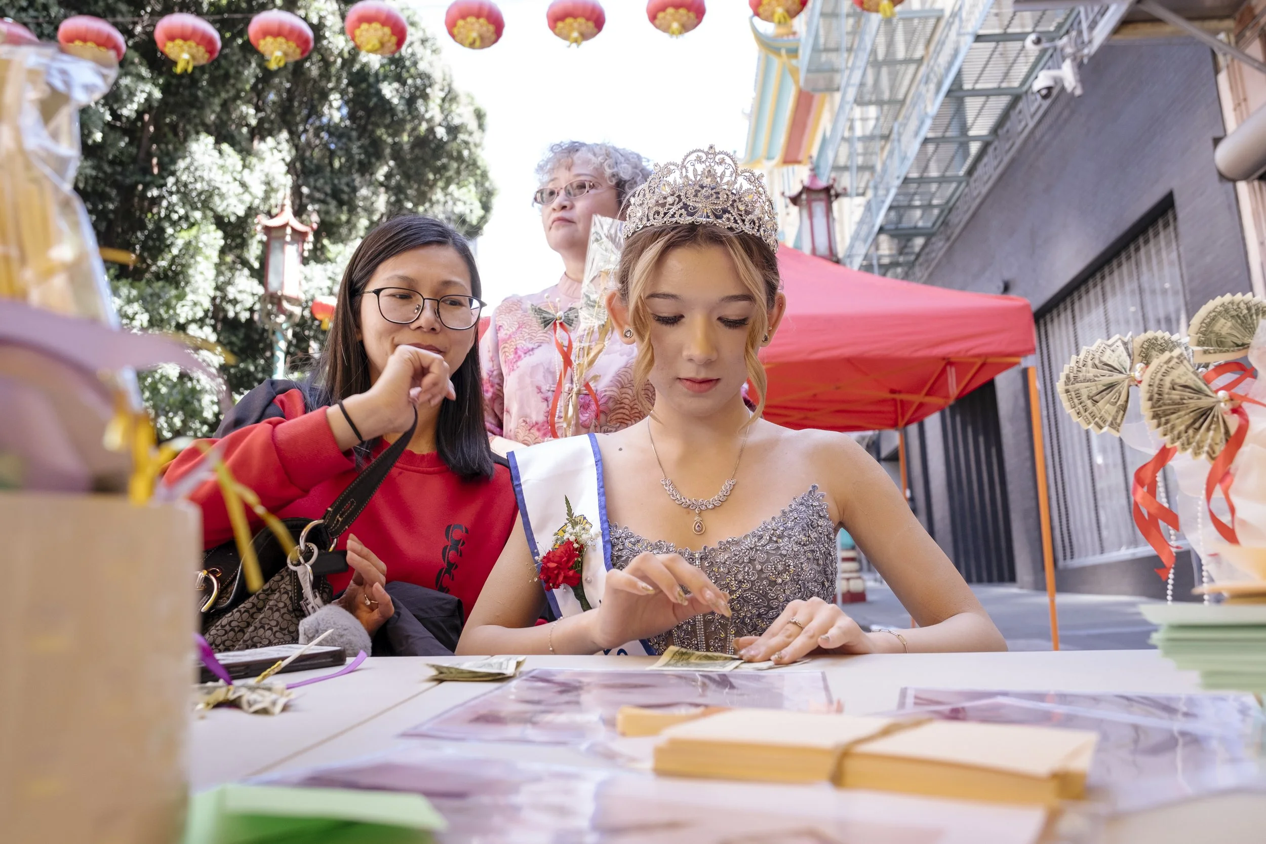 Kirby and her mom, Celene (left), learn to fold the traditional money origami, the lotus flower, at Chinatown's third annual cultural festival in San Francisco, California on May 31, 2026.  After the pandemic, many businesses in Chinatown struggled w
