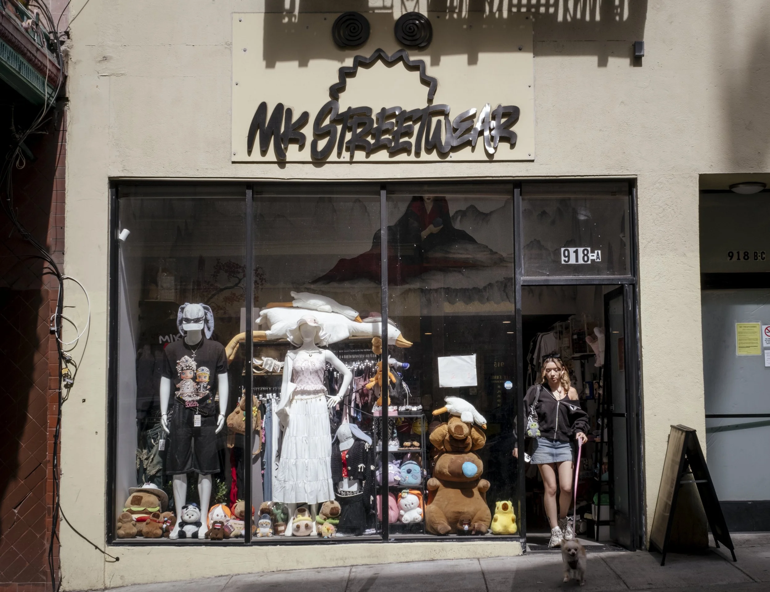 Kirby walks her puppy, Hoshii, out of her own store 'Milo Kerby Streetwear', to go pick up her friends in San Francisco, California on June 2, 2026. Kirby moved away from Chinatown when she was four, to Fairfax in Marin County.  "Safety in marin is s