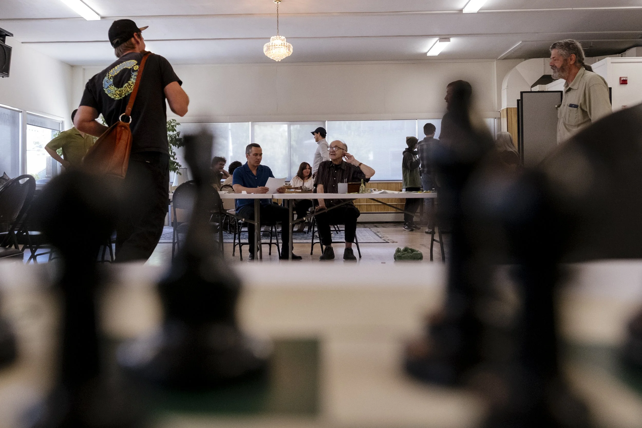 Wilton Strickland helps Nowak run the chess tournament at the Missoula Senior Center on May 23, 2026.  Nowak has given Strickland the community of chess in Missoula, and has even become a mentor to him.  “I try to be a mentor to him as well—he’s naiv
