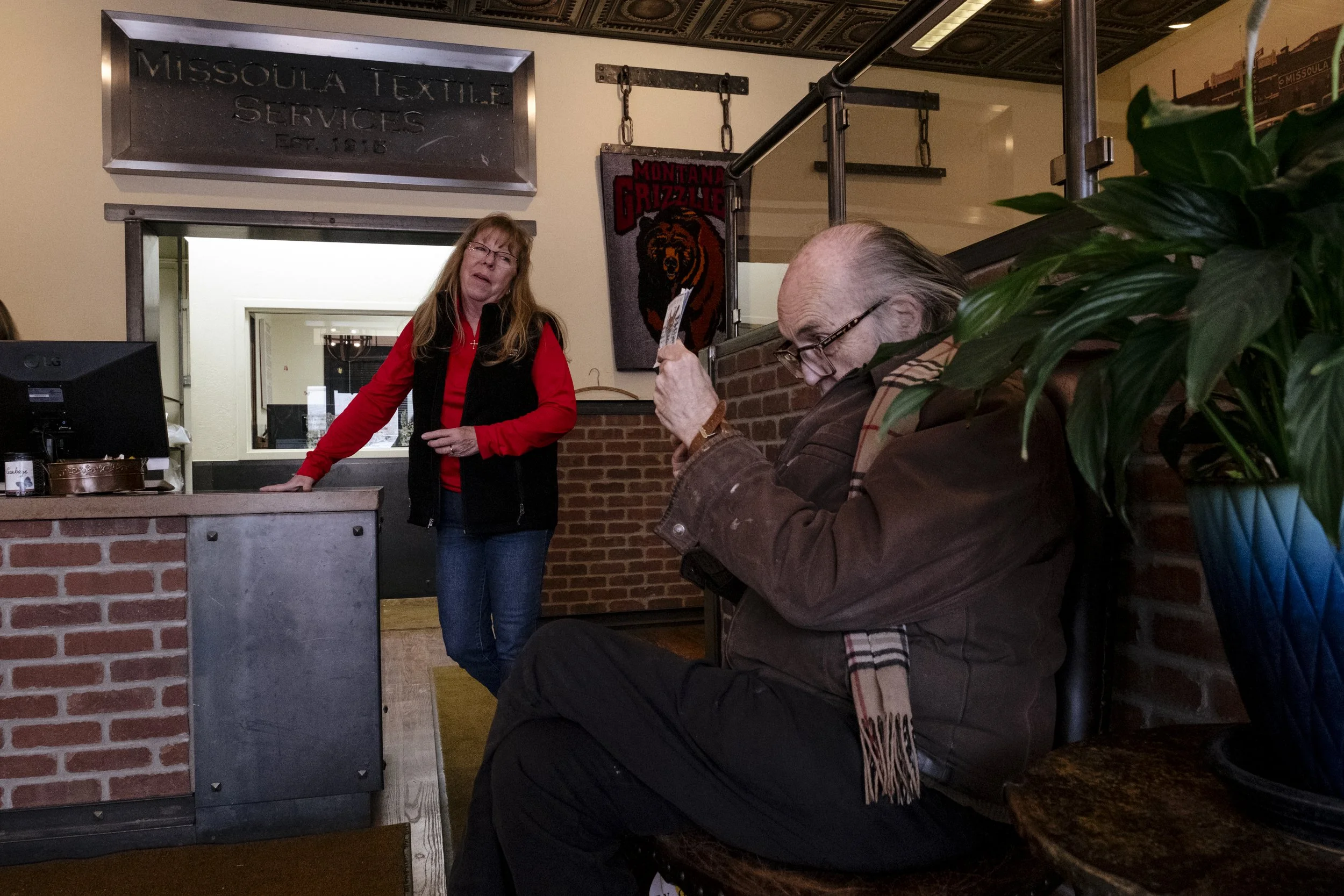 Nowak tells a joke to Stephanie Salvino, an employee at Missoula Textiles Services on April 13, 2026.  "He's been coming here for 36 years," said Salvino.  "He likes everything very particular".