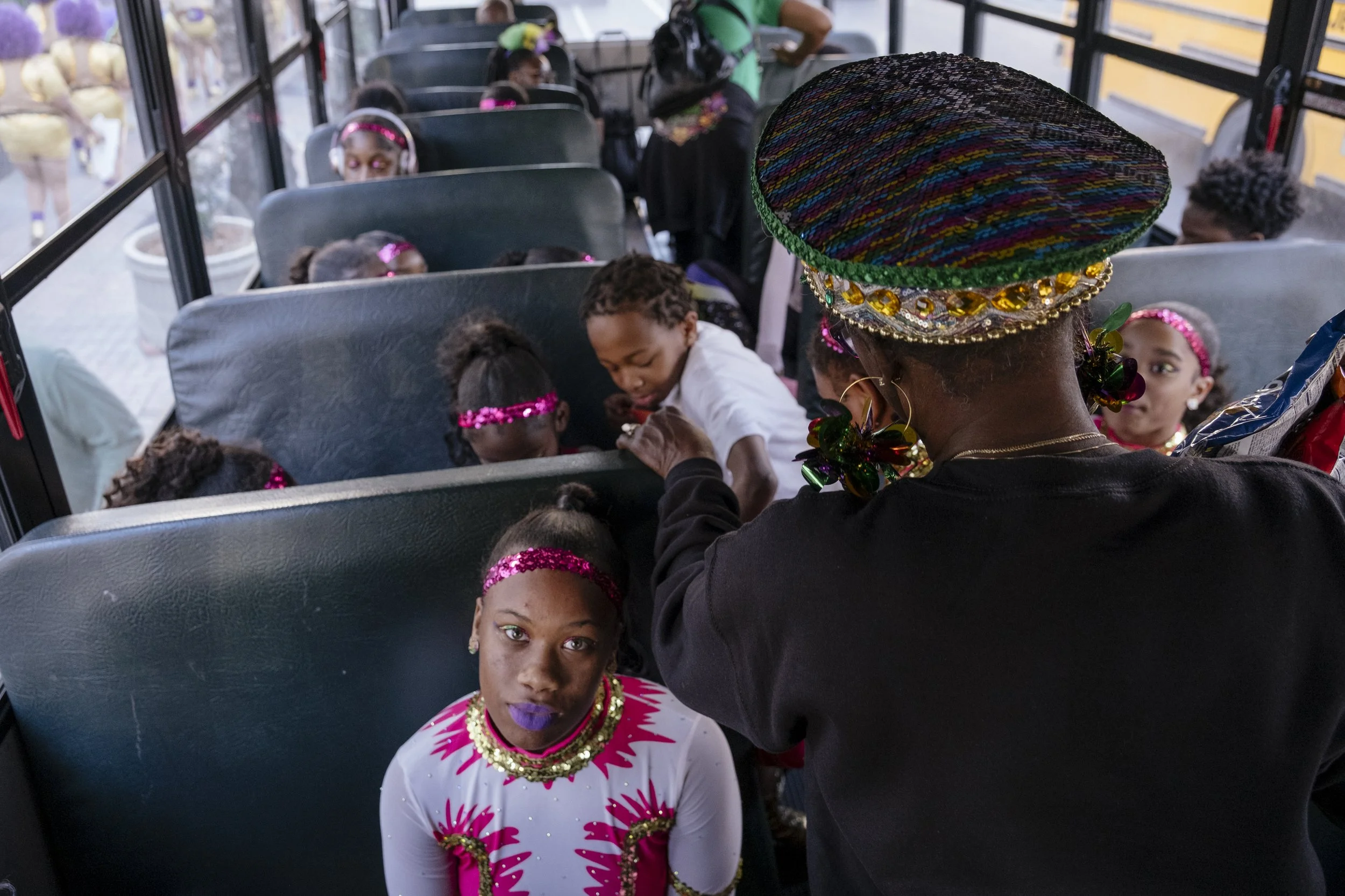 Members of the N.O.E Satin Dolls Dance wind down in the bus ride back to their studio after performing in the Mardi Gras Mystic krewe of Femme Fatale parade in New Orleans, Louisiana on February 8, 2026.  This was the only parade the Satin Dolls perf