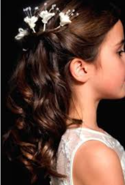 Profile of a young woman with long, curly brown hair wearing a floral headpiece.