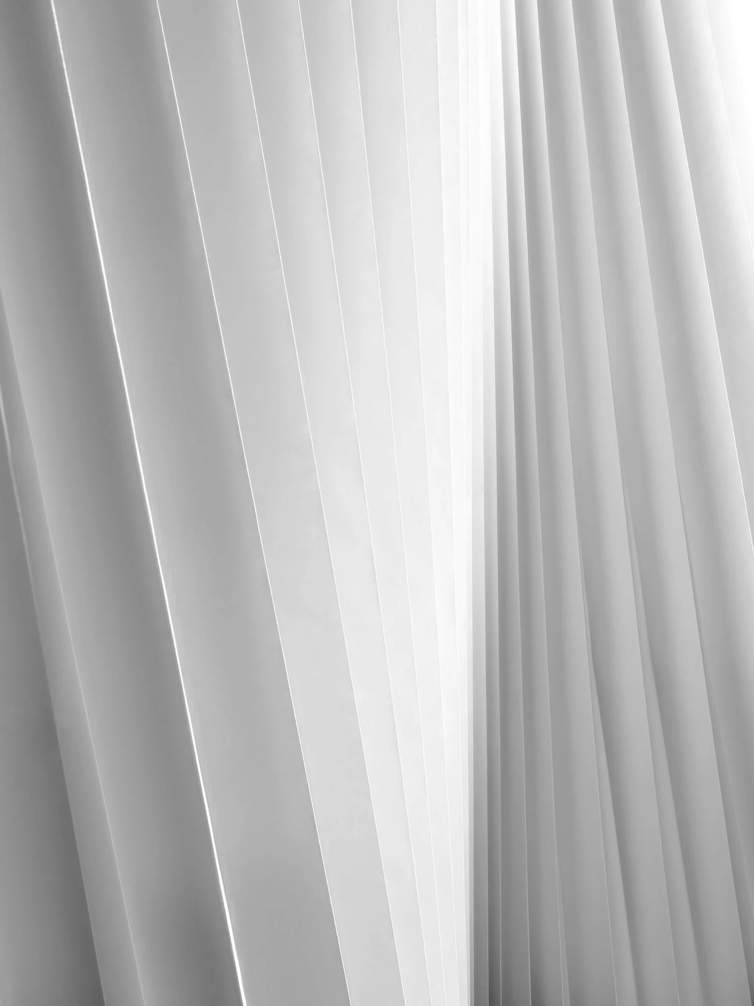 A gently curving landscape of pleated paper invites you in and offers a meditative experience in this serene black and white photograph.