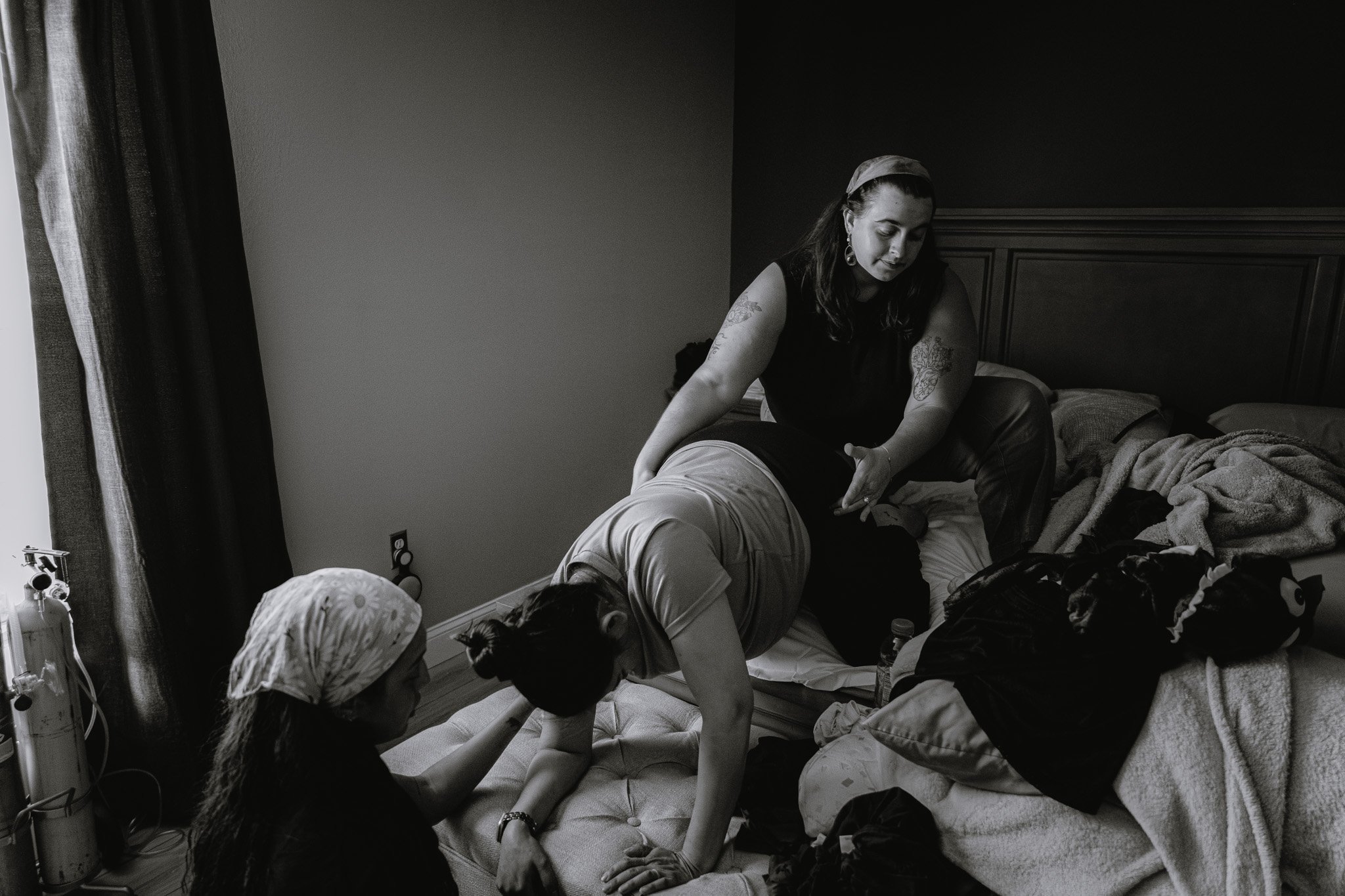 A woman sitting on a bed surrounded by children, engaging in a playful activity, possibly playing with the children.