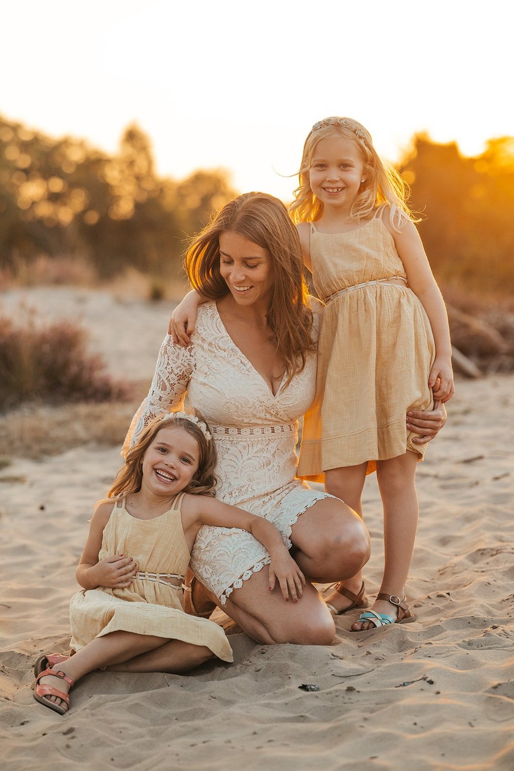 Mama met haar twee dochters in het zand