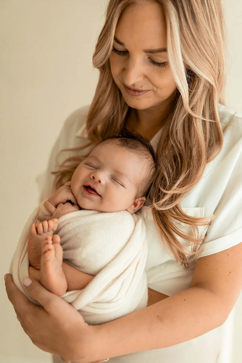 Lachende newborn in de armen van mama