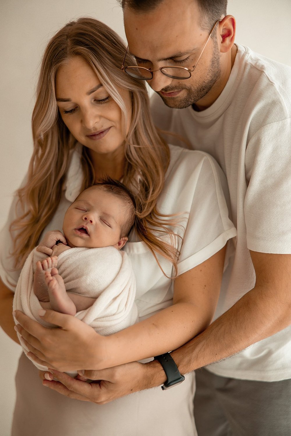 Papa en mama houden hun newborn samen vast