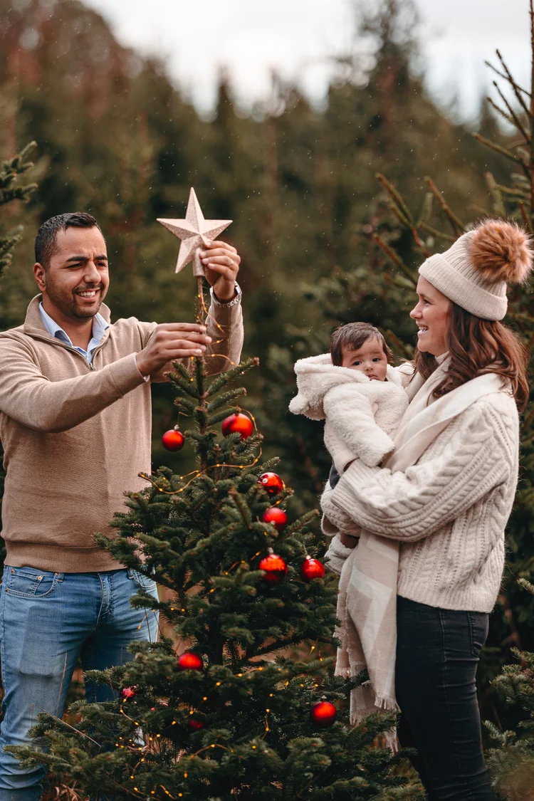 Papa zet de ster op de kerstboom