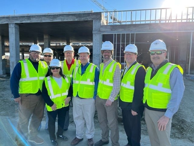 A group of engineers in hardhats and yellow vests