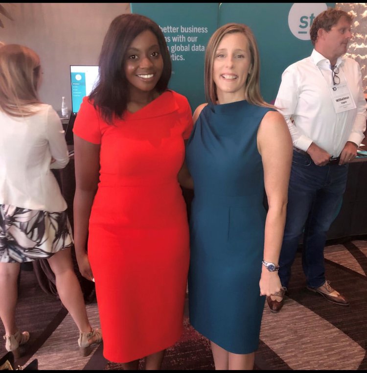 Stephanie taking a picture with a woman at an event