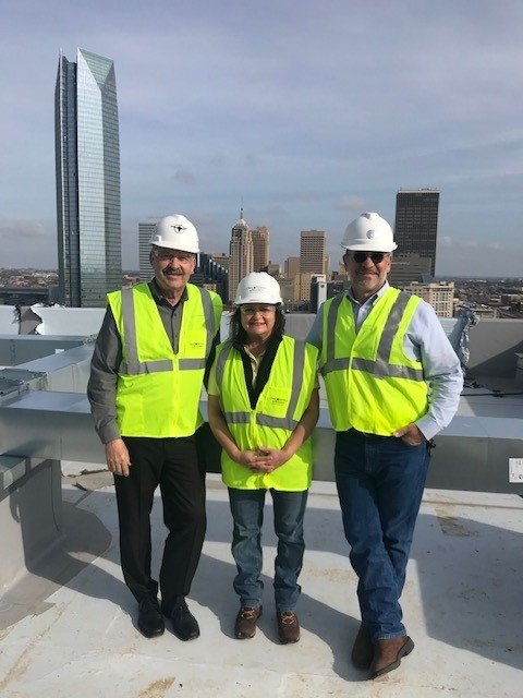 Nora standing on a roof of a building with two other engineers