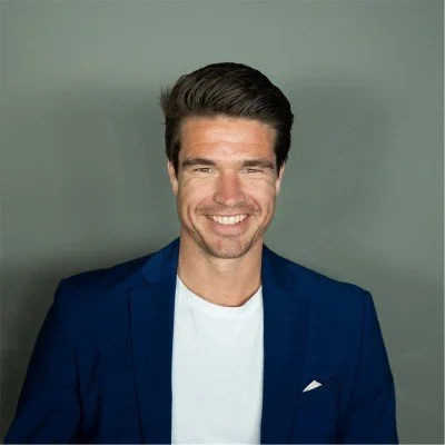 Portret van een lachende man in een blauwe jas en witte t-shirt