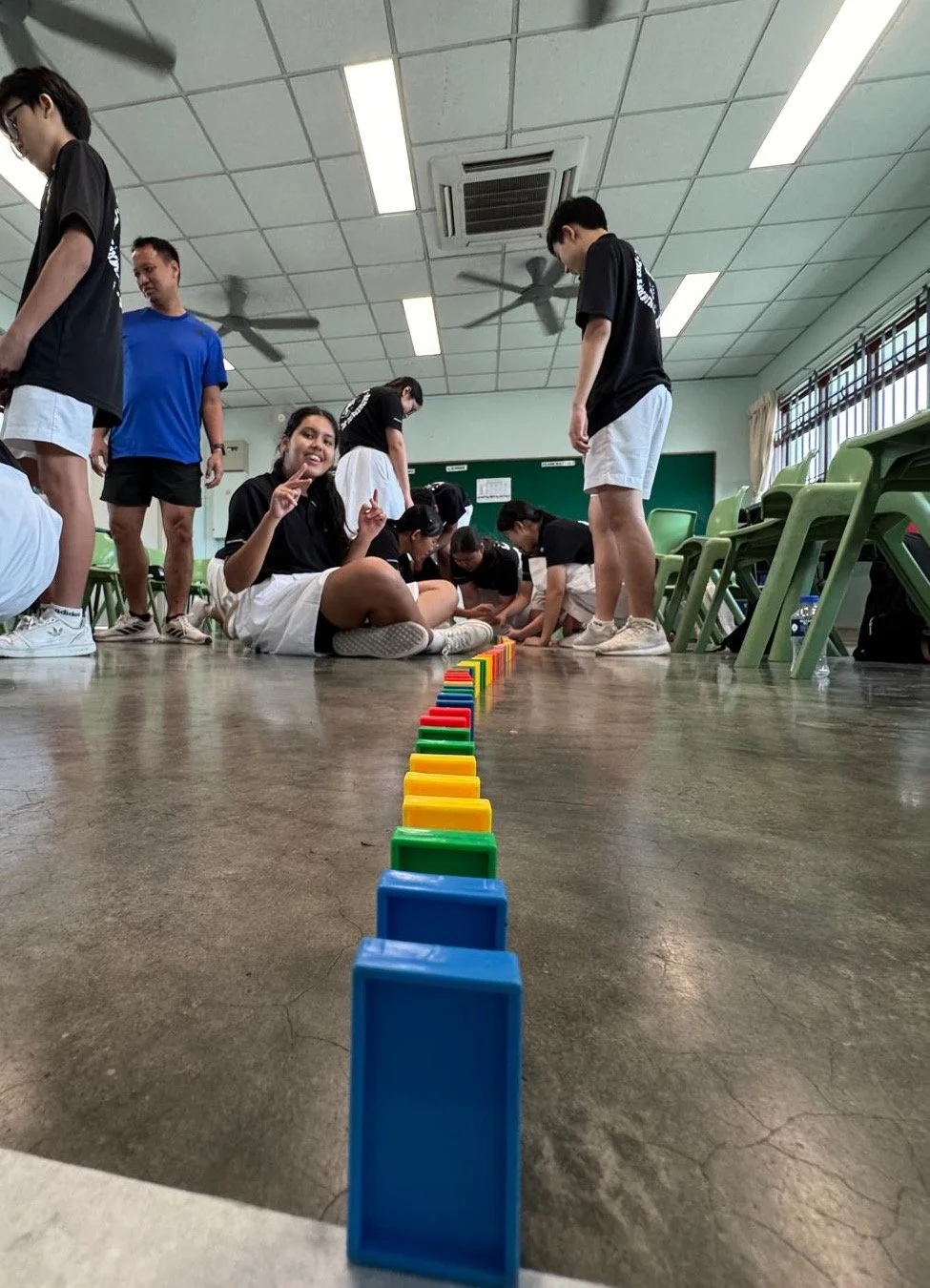 Student leaders build a domino line during a Leaven Academy leadership workshop