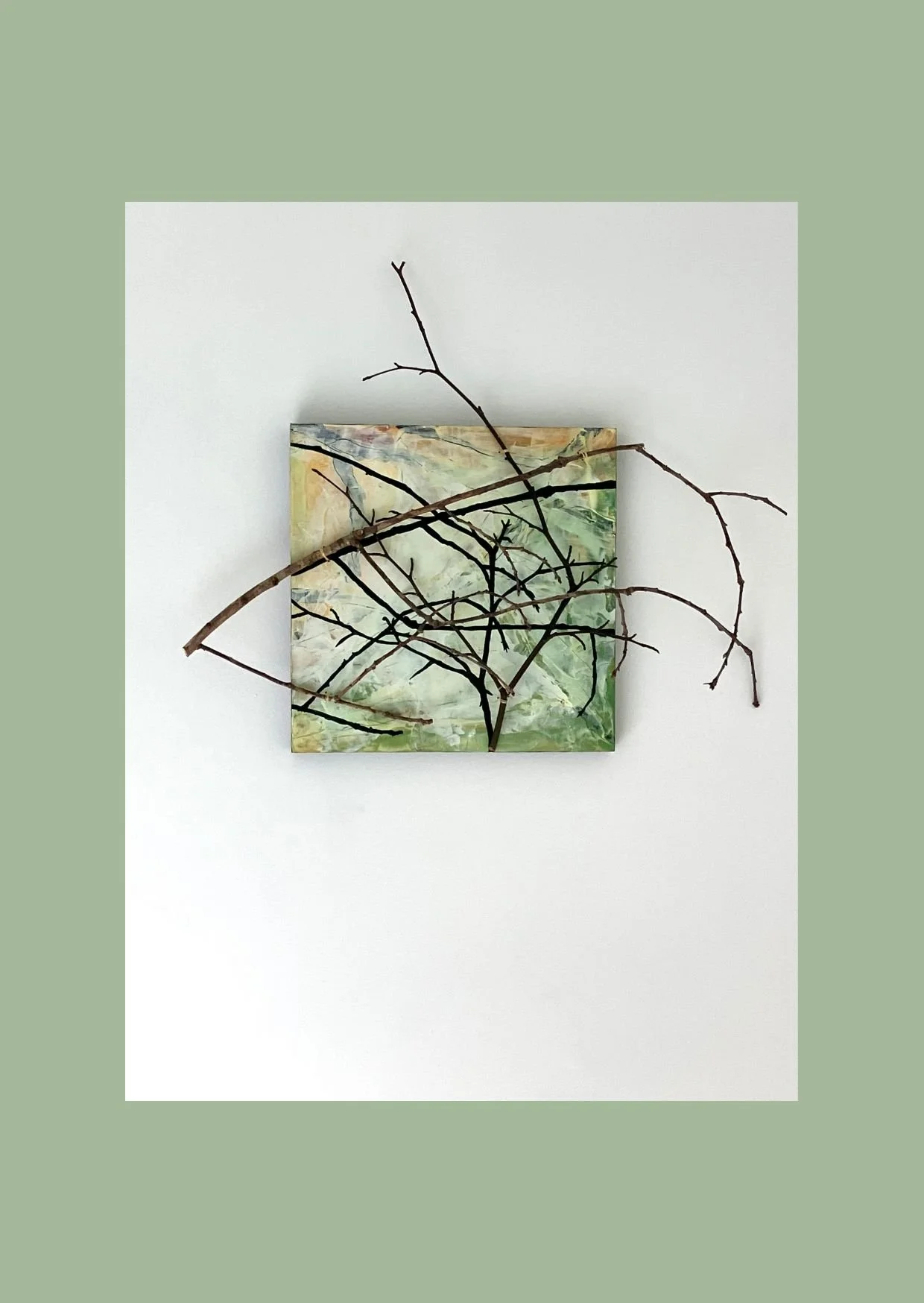 Painting in greens, yellows and cream with twig attached to the board and its shadow painted on to the surface.