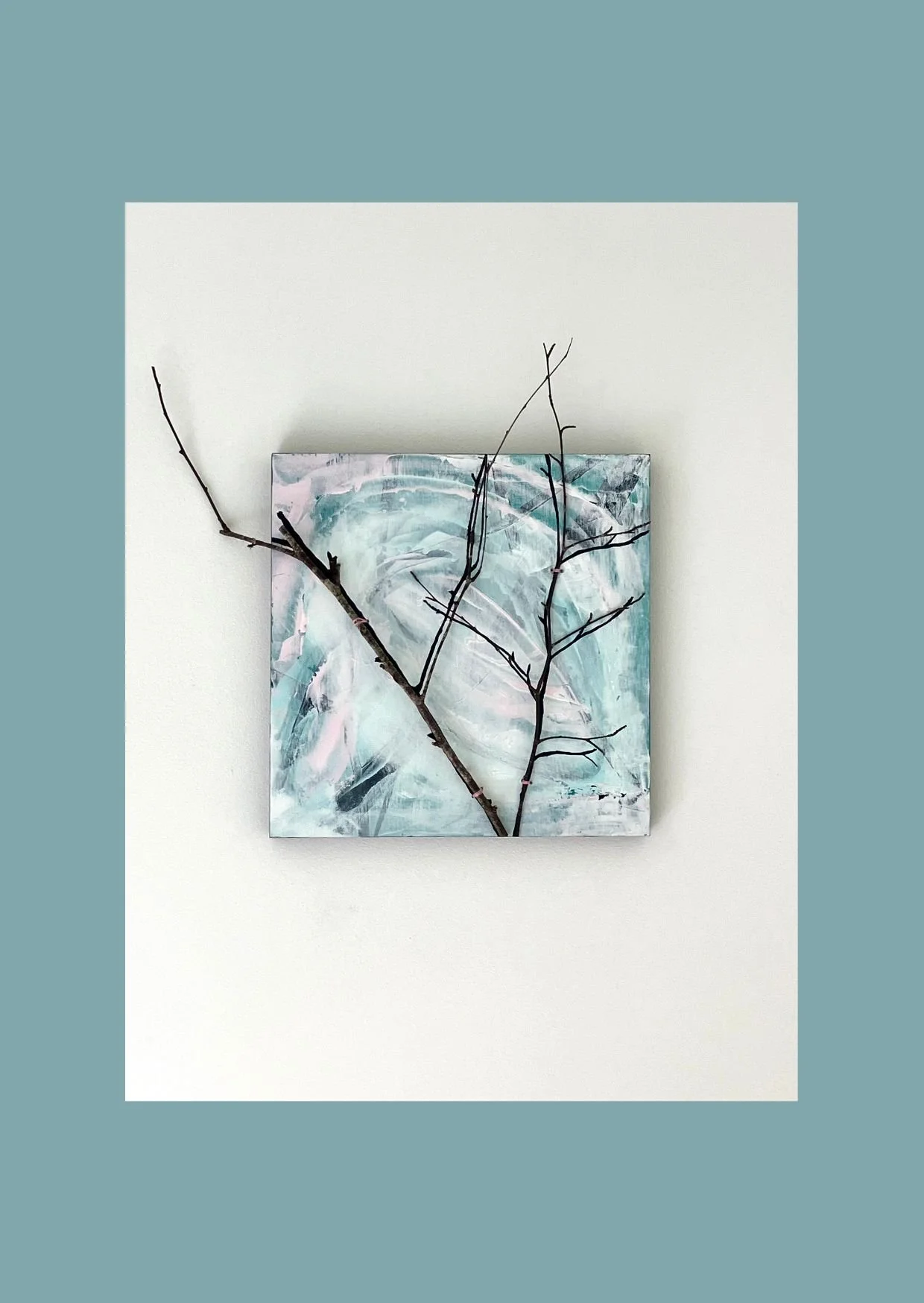 Painting in blues, pinks and whites with a twig attached to the painting and its shadow painted in dark colour.