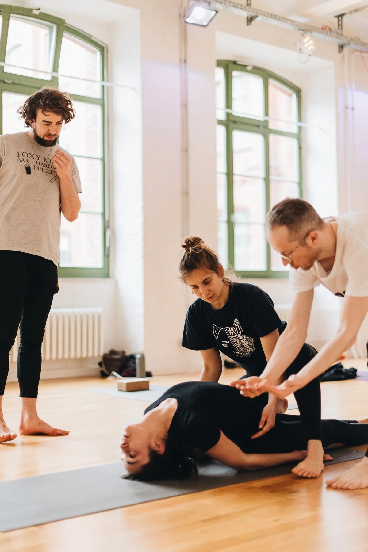 yoga teacher assisting a student in asana practice
