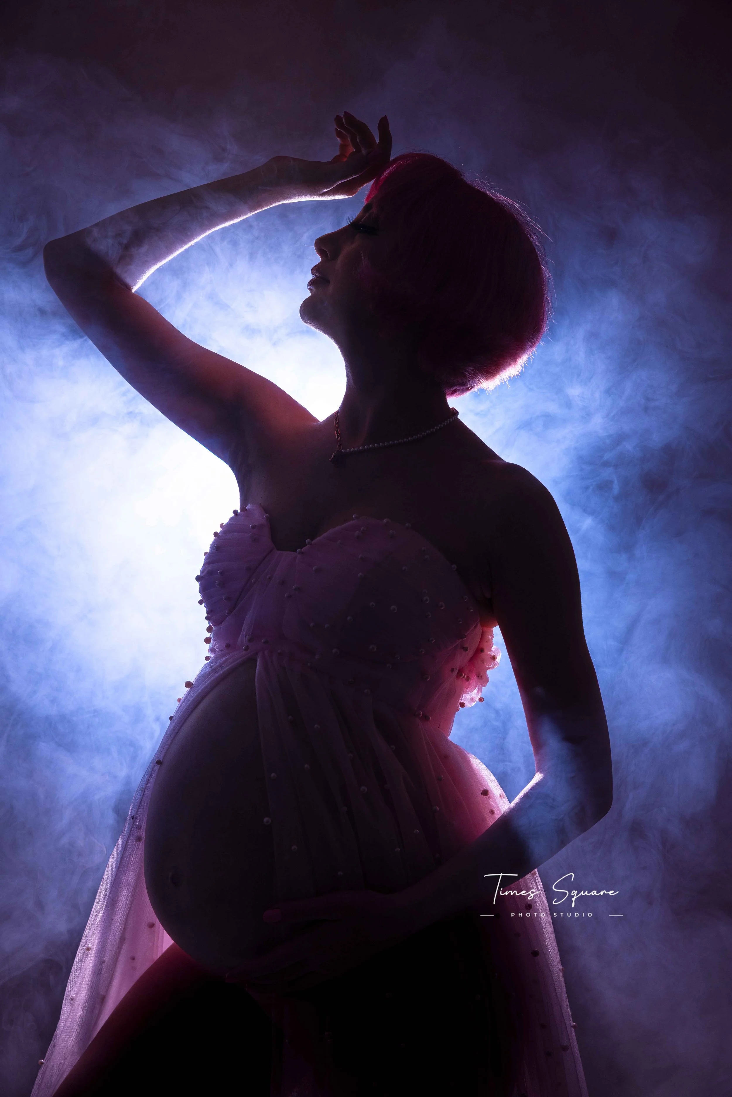 Silhouette of a woman with short hair in a dreamy, foggy setting, wearing a pink dress with pearls, backlit for a dramatic effect.