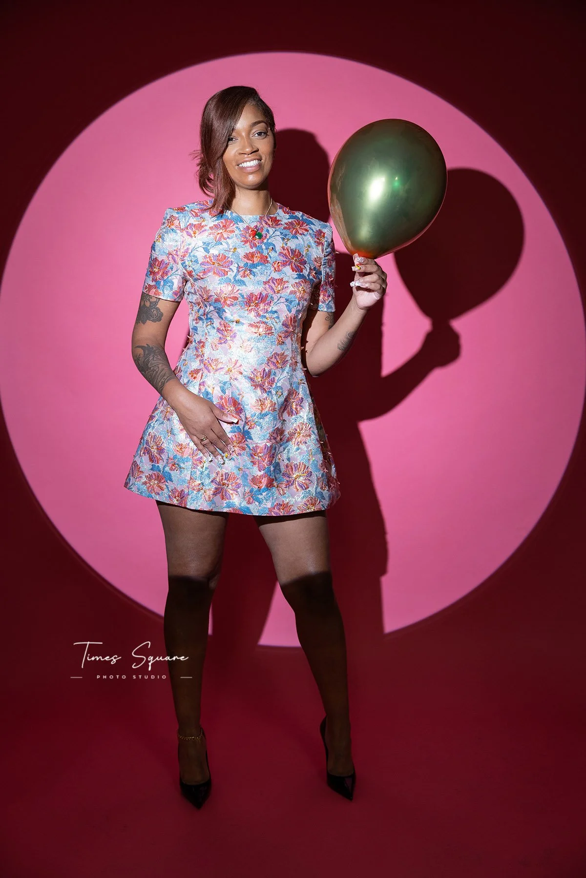 Birthday photoshoot portrait in NYC studio with pink backdrop and spotlight lighting.